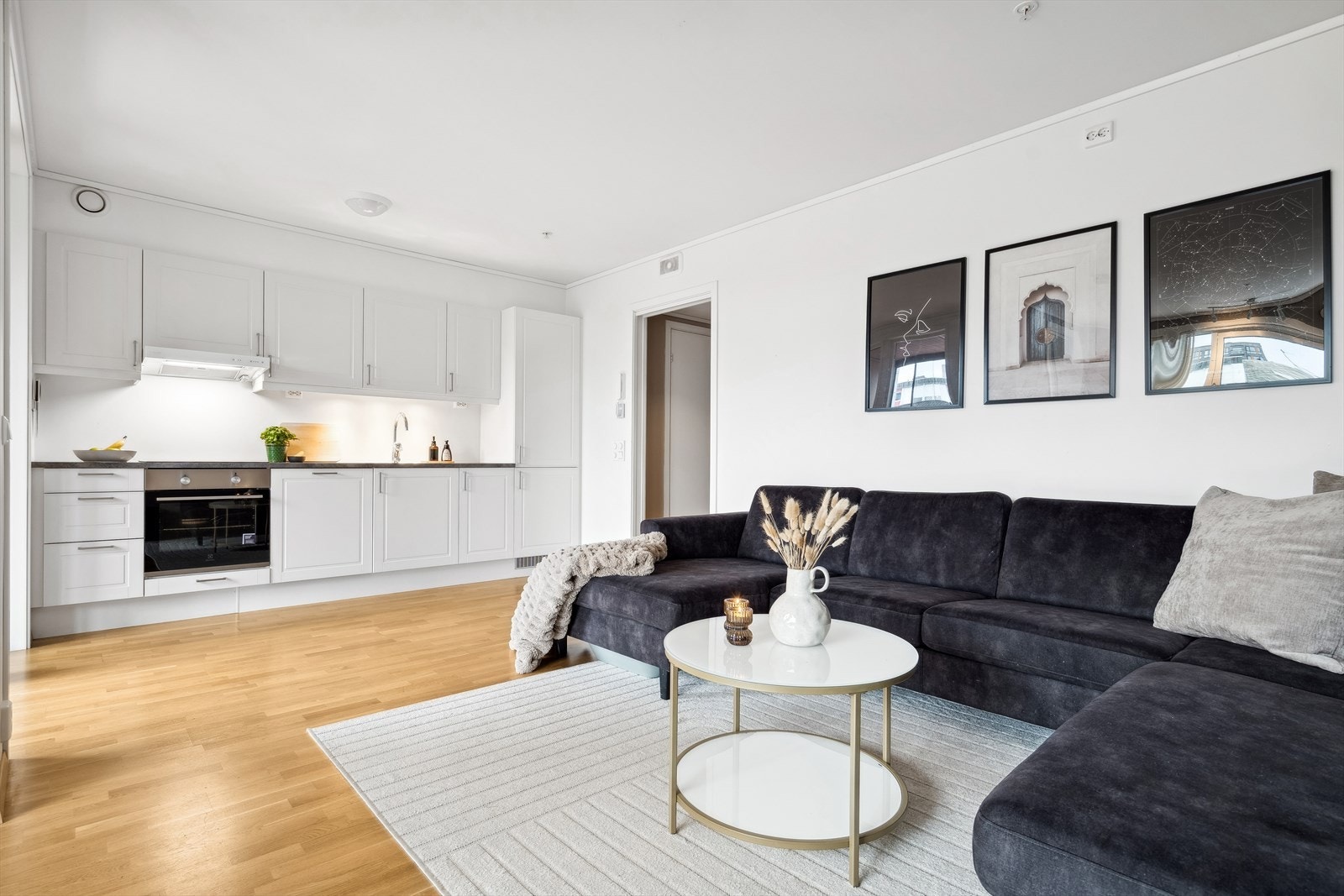 Innredningen har hvite profilerte fronter og en grå laminatbenkeplate. Den er praktisk utbygget med plass på benk, i skap og i skuffer. Galleribilde