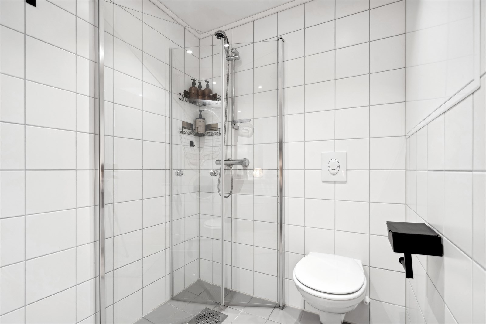 Badet har vegghengt toalett og dusjhjørne med innfellbare glassdører for ekstra plassbesparelse. Galleribilde