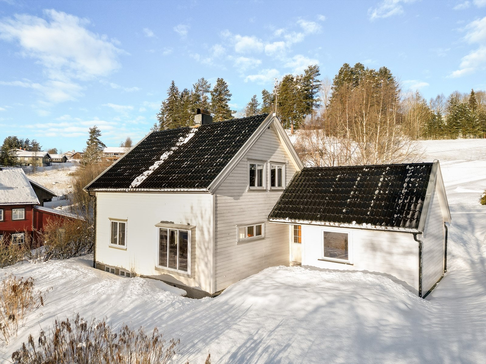 Tomten på 954.2 m2 er pent opparbeidet med plen og variert beplantning. Gruslagt gårdsplass og biloppstillingsplasser. Det er også parkering i garasje nedenfor boligen. Galleribilde