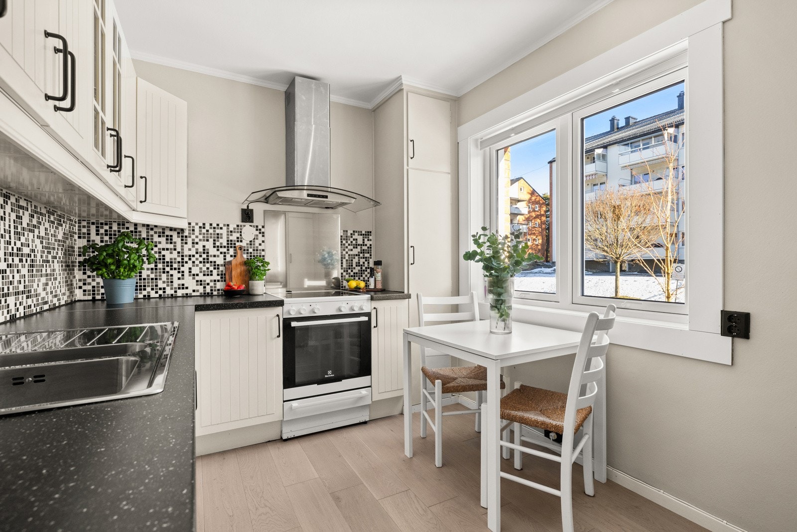 Fin IKEA kjøkkeninnredning fra 2004 med hvite profilerte fronter. Galleribilde