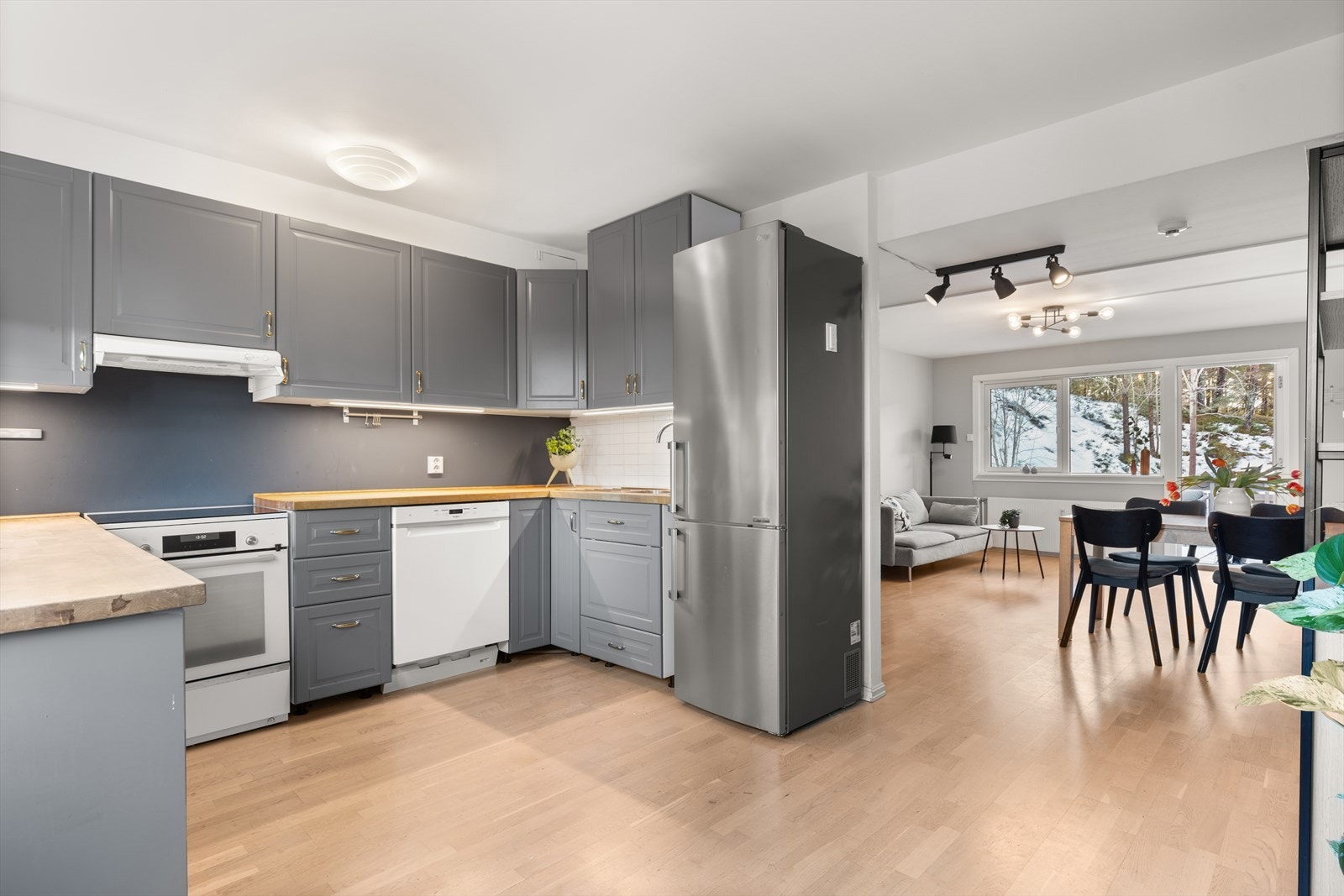 Kjøkkenet har innredning med laminerte skrog og profilerte fronter og heltrebenkeplate med nedfelt oppvaskkum Galleribilde