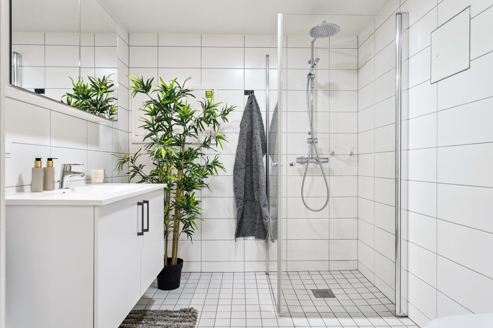 Badet har regnfallsdusj i et hjørne med innfellbare glassdører. Galleribilde