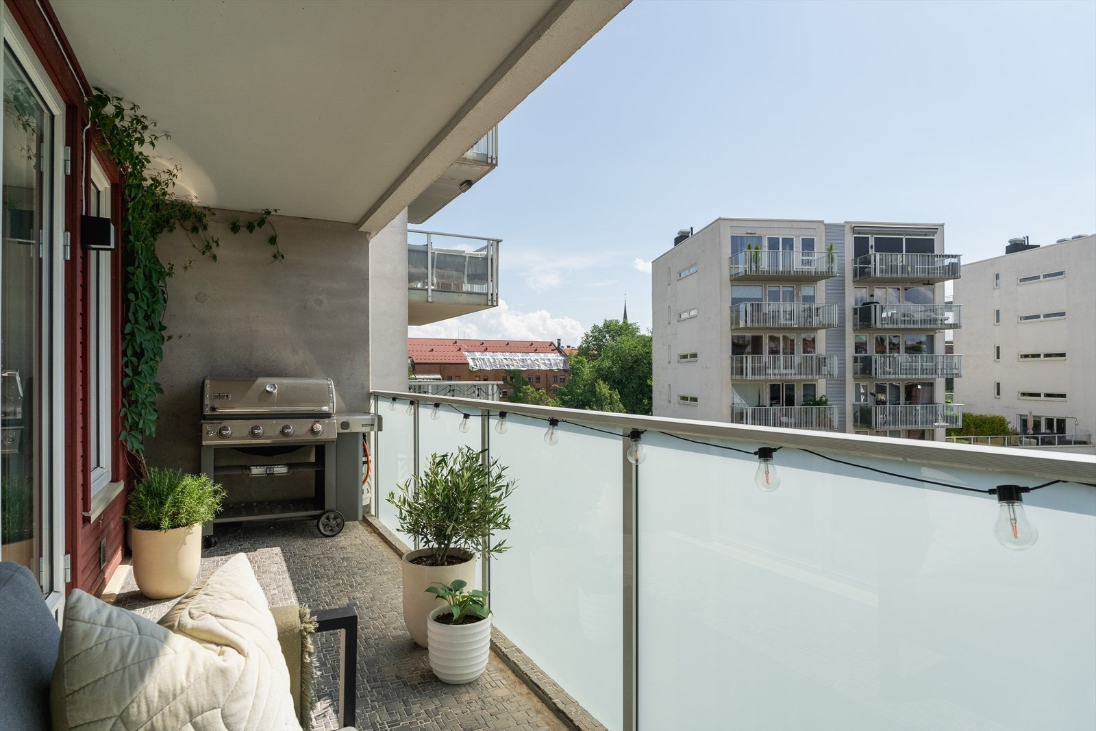 Balkongen har fliser på gulv, lys, stikkontakt og terrassevarmer Galleribilde