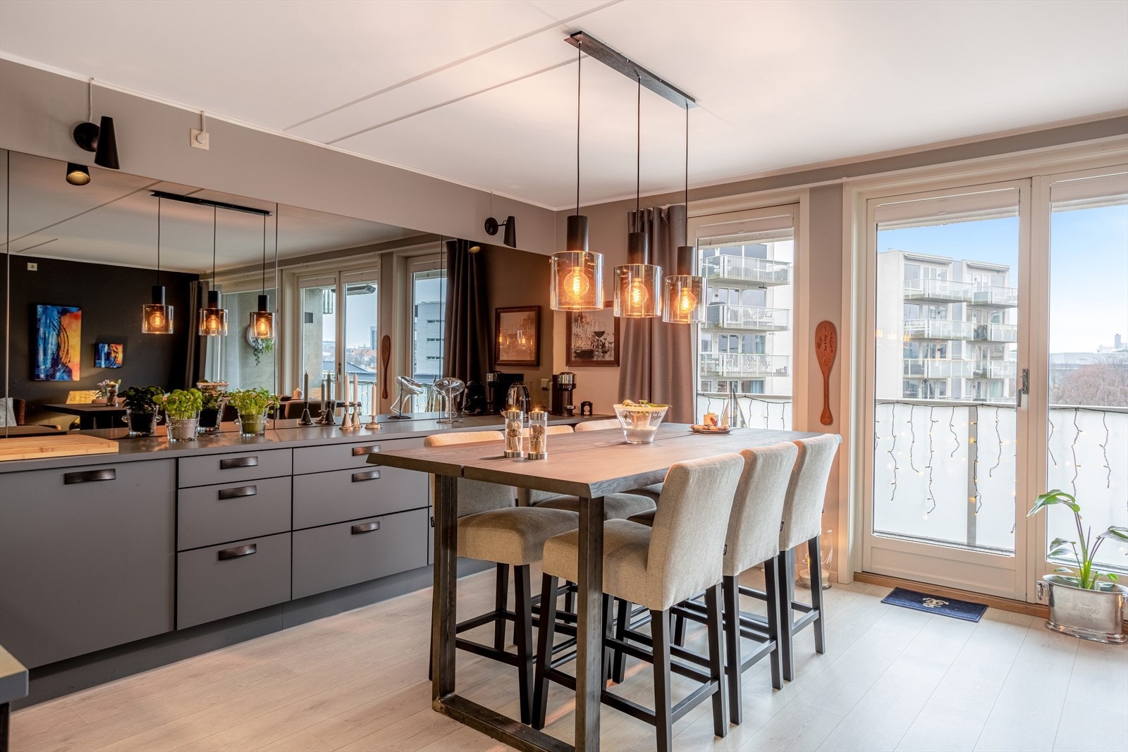 Moderne HTH kjøkken fra 2019 bestående av slette lakkerte fronter, laminat benkeplate med sprutplate og speil over, enkel underlimt kompositt oppvaskkum og kjøkkenventilator i stål med kullfilter Galleribilde