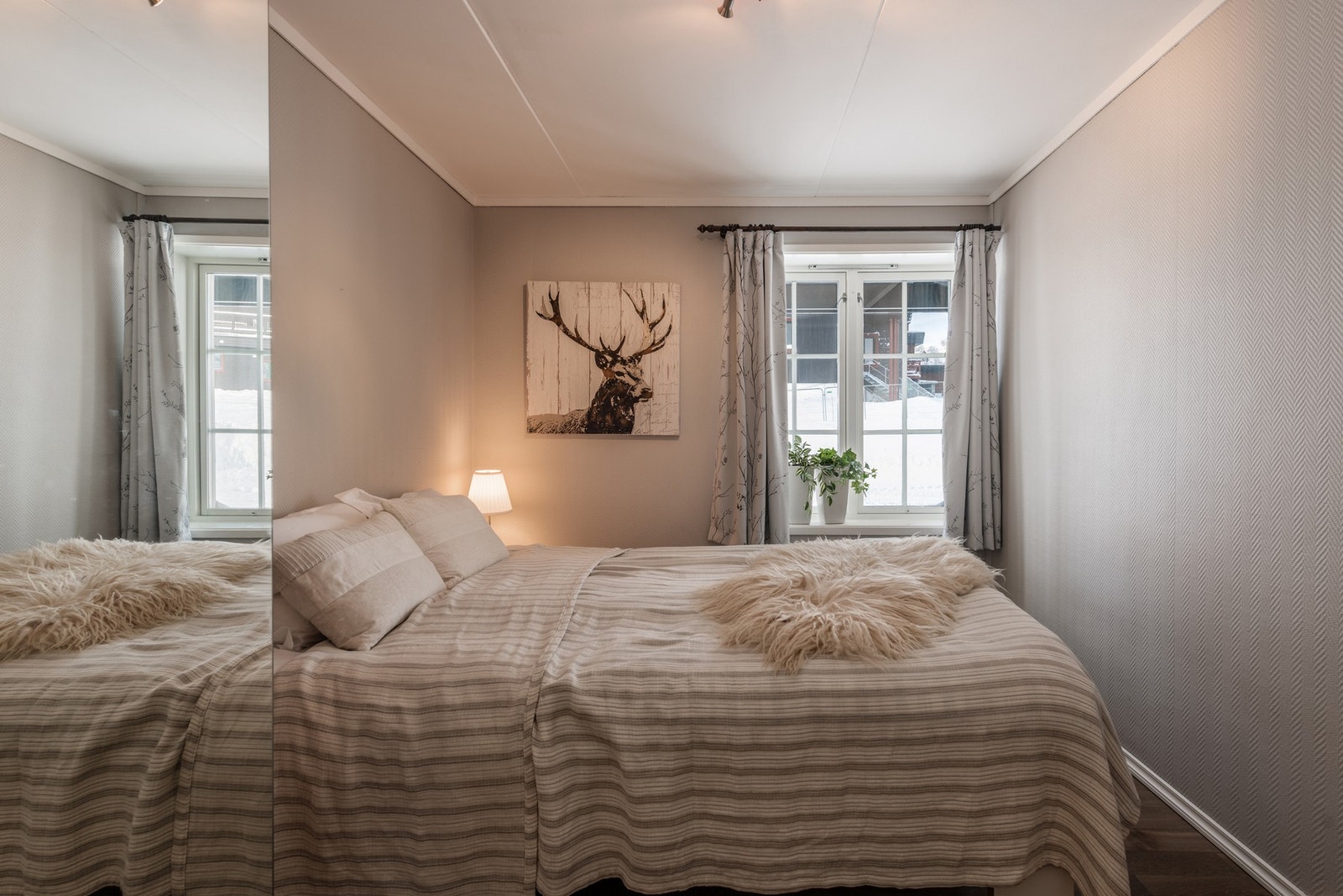 Lyst og lekkert soverom, med god plass til garderobeskap og dobbeltseng Galleribilde