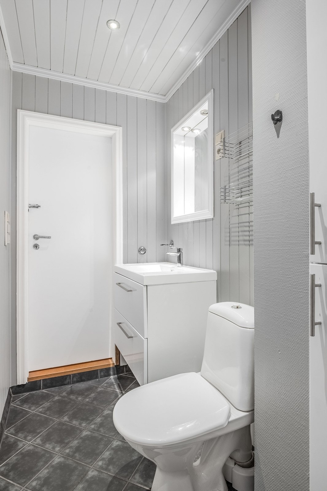 Innredningen består av servantskap, gulvfestet toalett og et høyskap. Det er varmekabler på gulv for en lun følelse under føttene og downlights i tak. Galleribilde