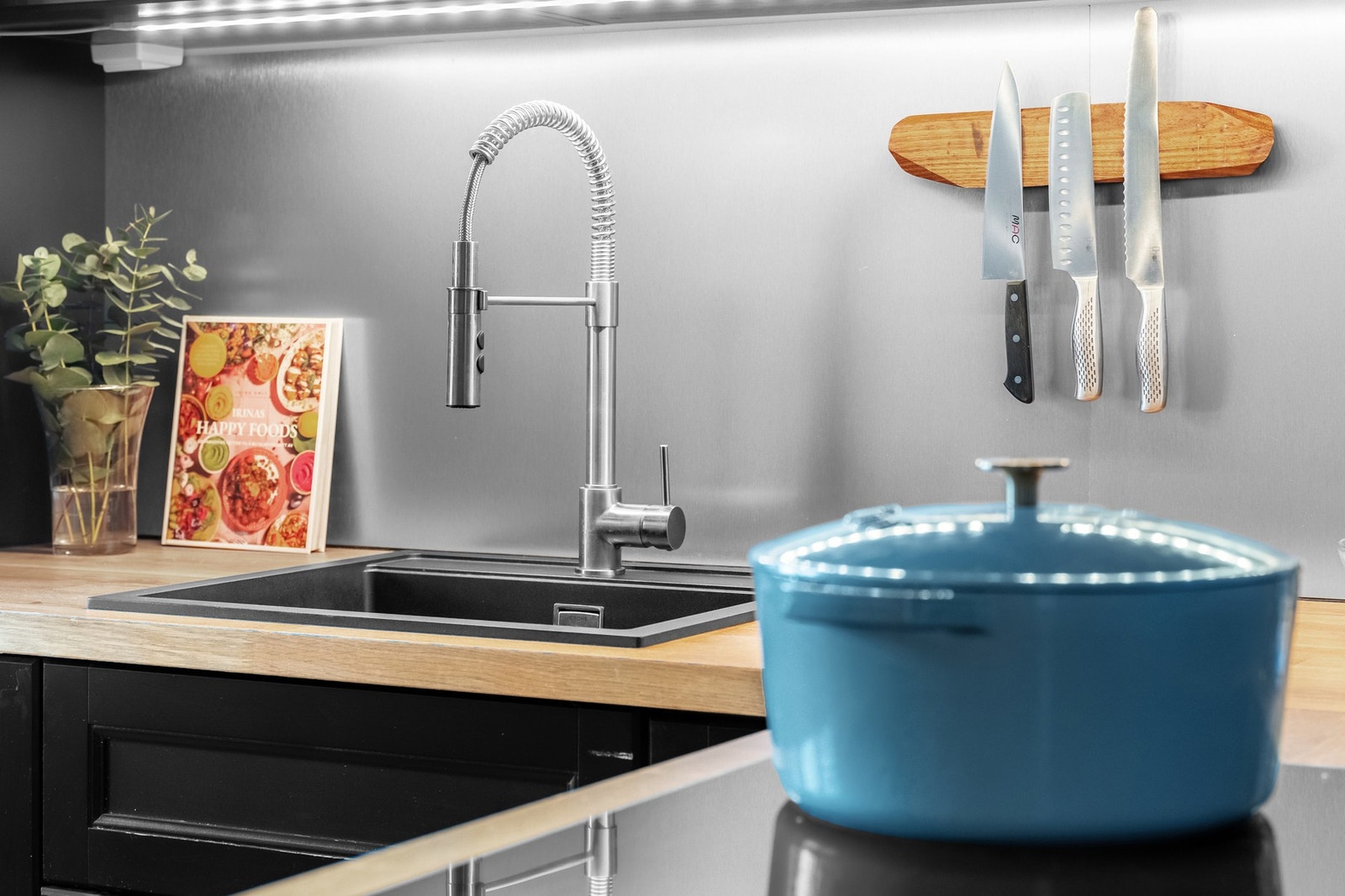 Videre har kjøkkenet integrerte hvitevarer som kjøl/frys, oppvaskmaskin, mikrobølgeovn, stekeovn og platetopp. Over platetoppen er det en vegghengt ventilator. Galleribilde