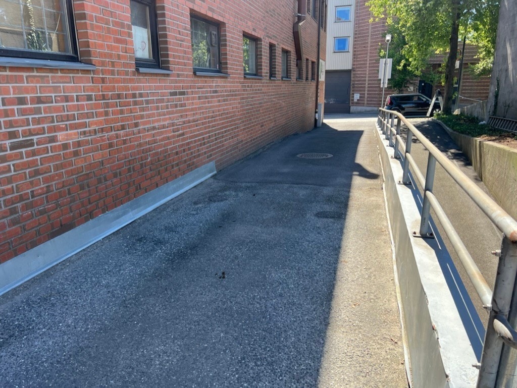 Innkjøring til parkering bakgård og p-kjeller. Området er modernisert noe siden bildet er tatt. Galleribilde
