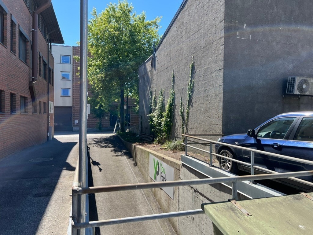 Innkjøring til parkering bakgård og p-kjeller. Området er modernisert noe siden bildet er tatt. Galleribilde