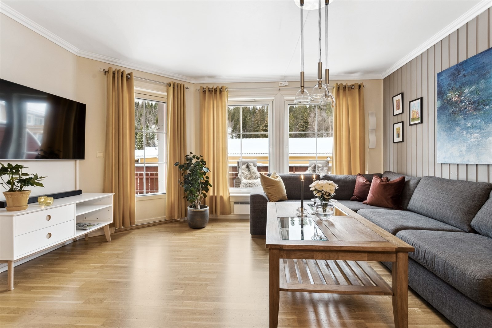 Den lyse og luftige stuen har en gjennomgående god standard og et tidløst preg med parkett på gulv, samt en kombinasjon av panelplater og malt gips på veggene. Galleribilde