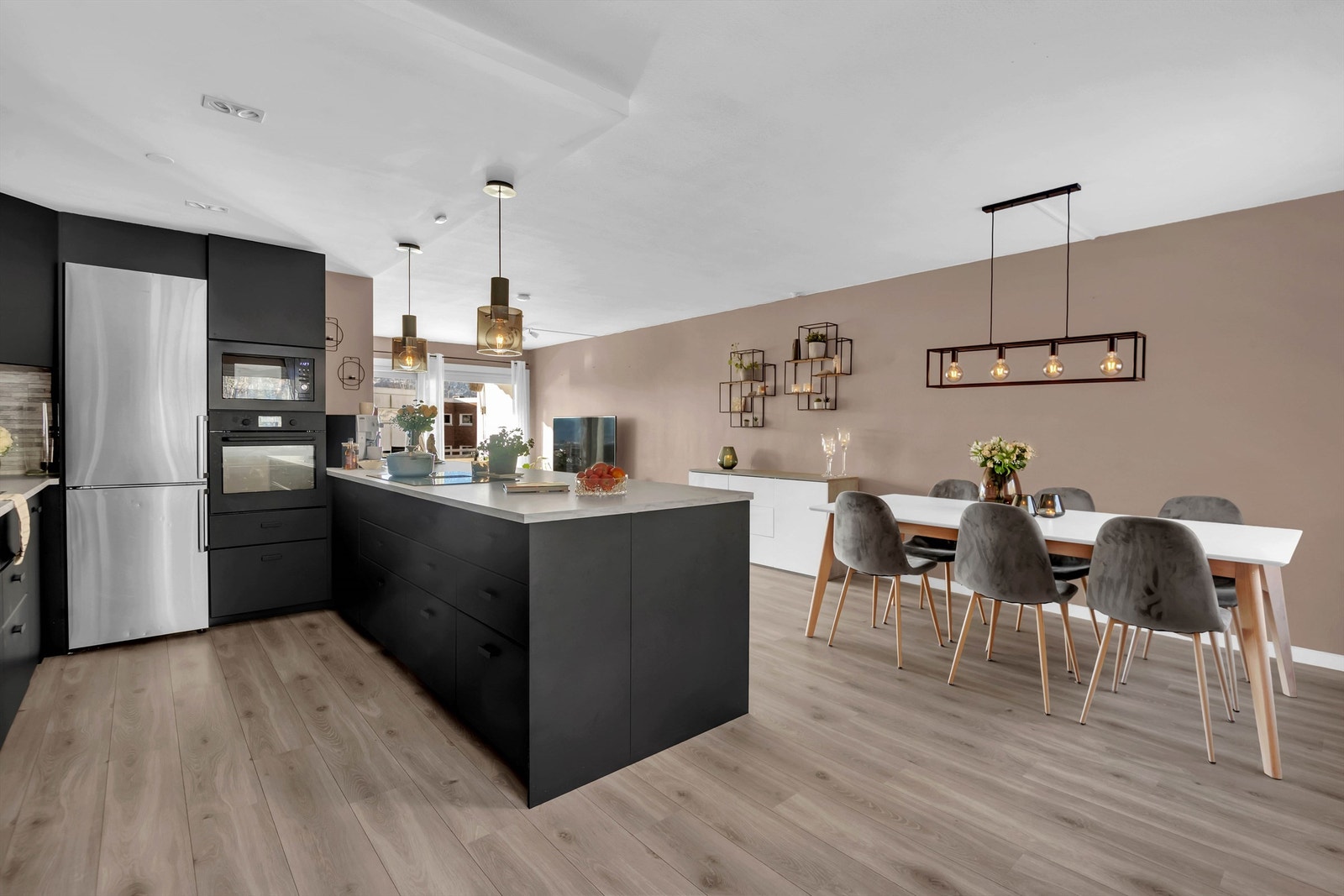 Innredning med slette fronter og benkeplate av laminat med sponkjerne, flis på vegg over benk, oppvaskkum i stål med 1-greps blandebatteri og avløpsrør av plast. Galleribilde