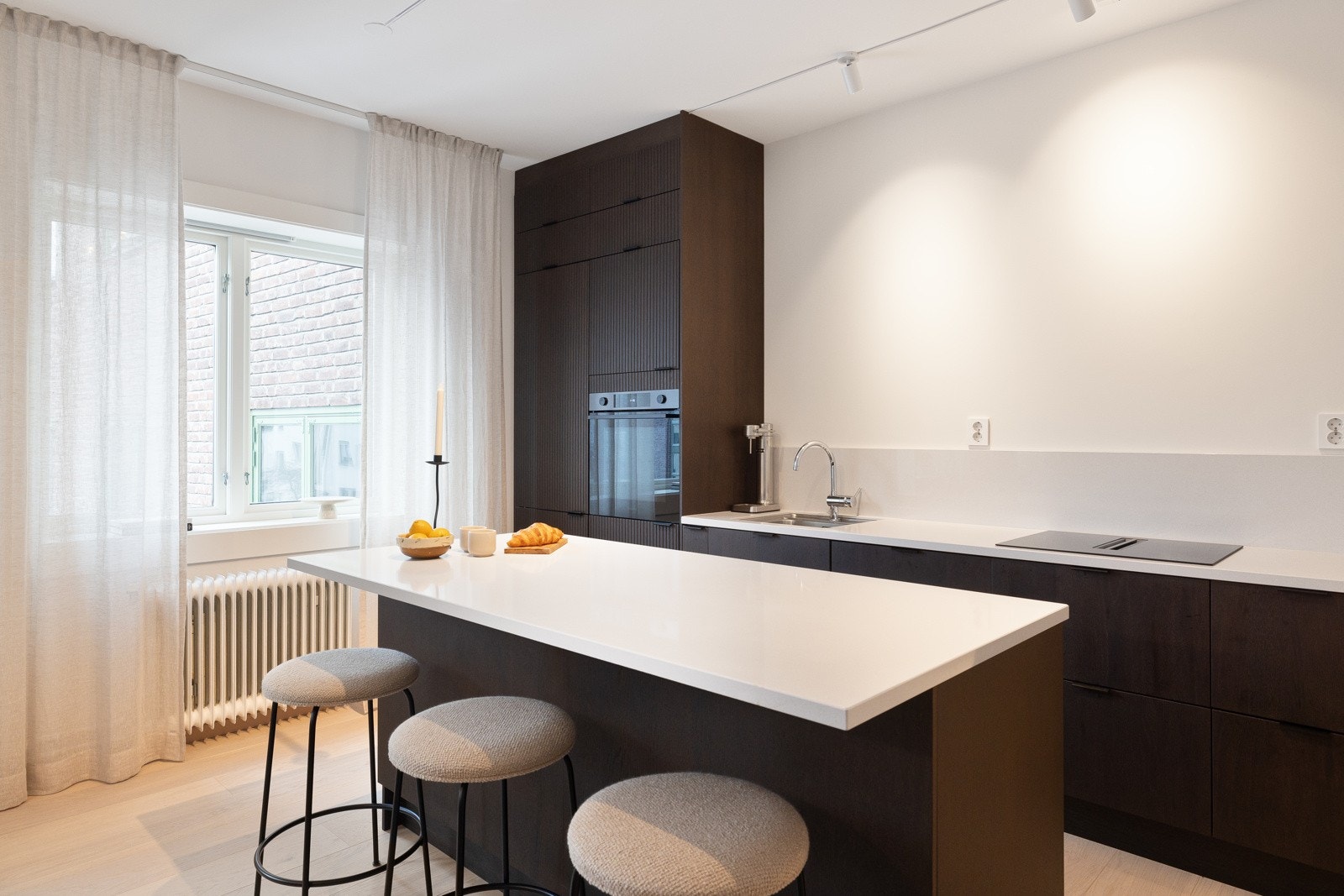 Lekkert kjøkken med eikefronter og påkostet benkeplate i komposittstein. Galleribilde