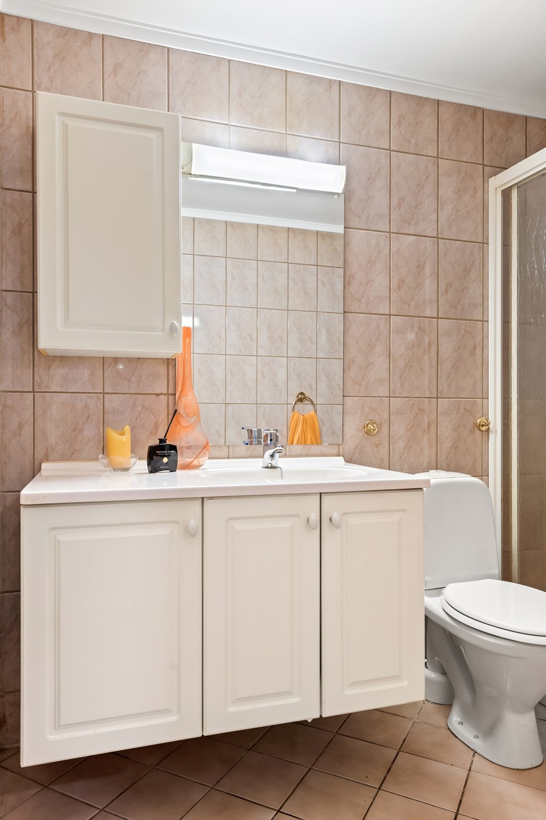 Videre er det oppbevaring i skapinnredning med nedfelt servant, speil med lys og gulvfestet toalett. Galleribilde