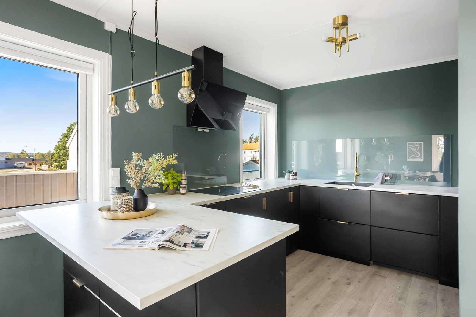 Her har du et moderne kjøkken med kjøkkeninnredning med slette fronter. Laminat benkeplate med glassplater over benk ved koketopp og vask. Galleribilde