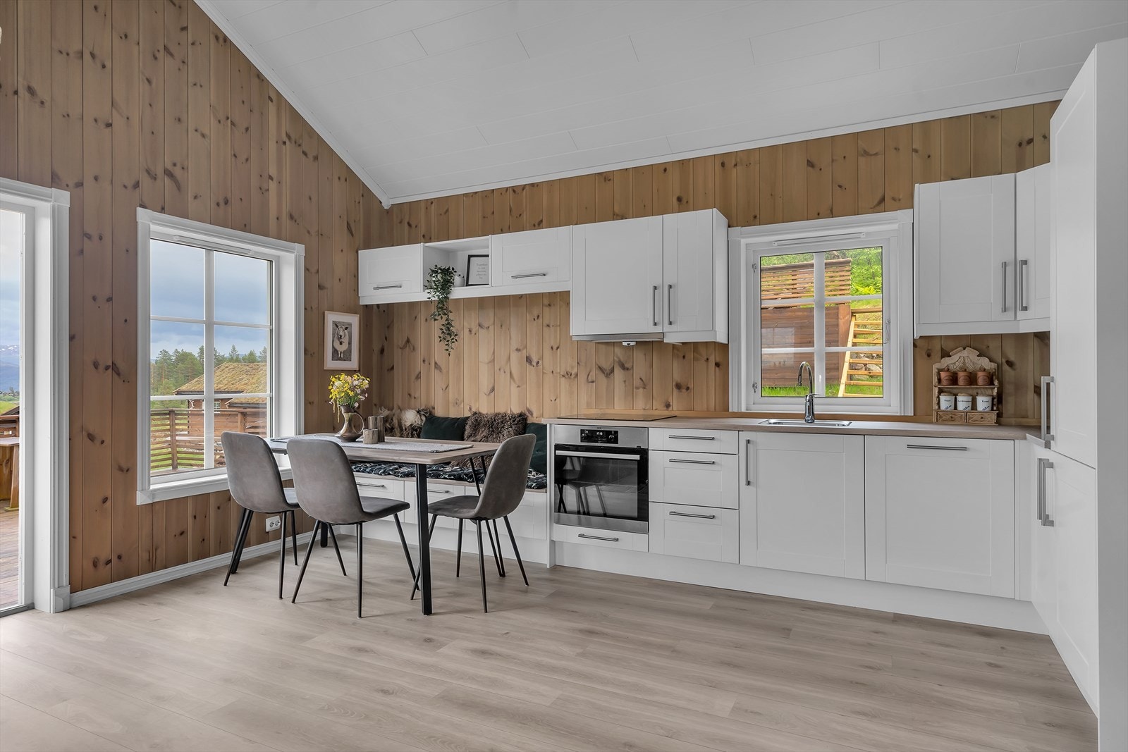 Flott lyst kjøkken med moderne innredning med hvite fronter og laminert benkeplate Galleribilde