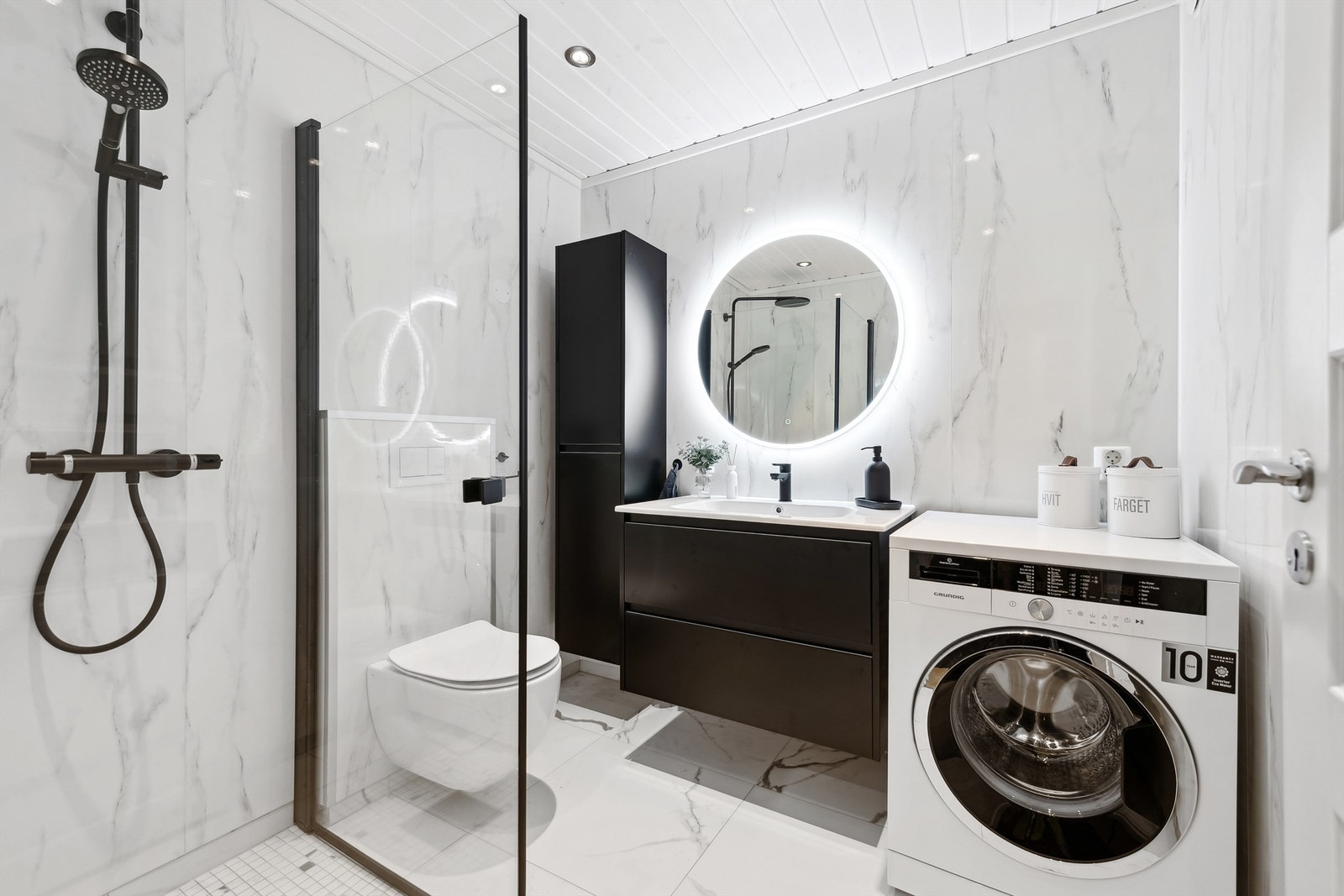 Pent baderom fra 2023 med vegghengt toalett, innfellbare dusjvegger og varmekabler i gulv. Galleribilde