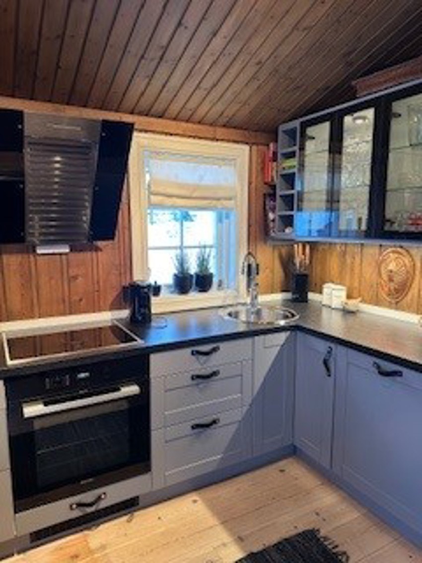 Overskap på kjøkkeninnredningen med glassfronter og lys. Galleribilde