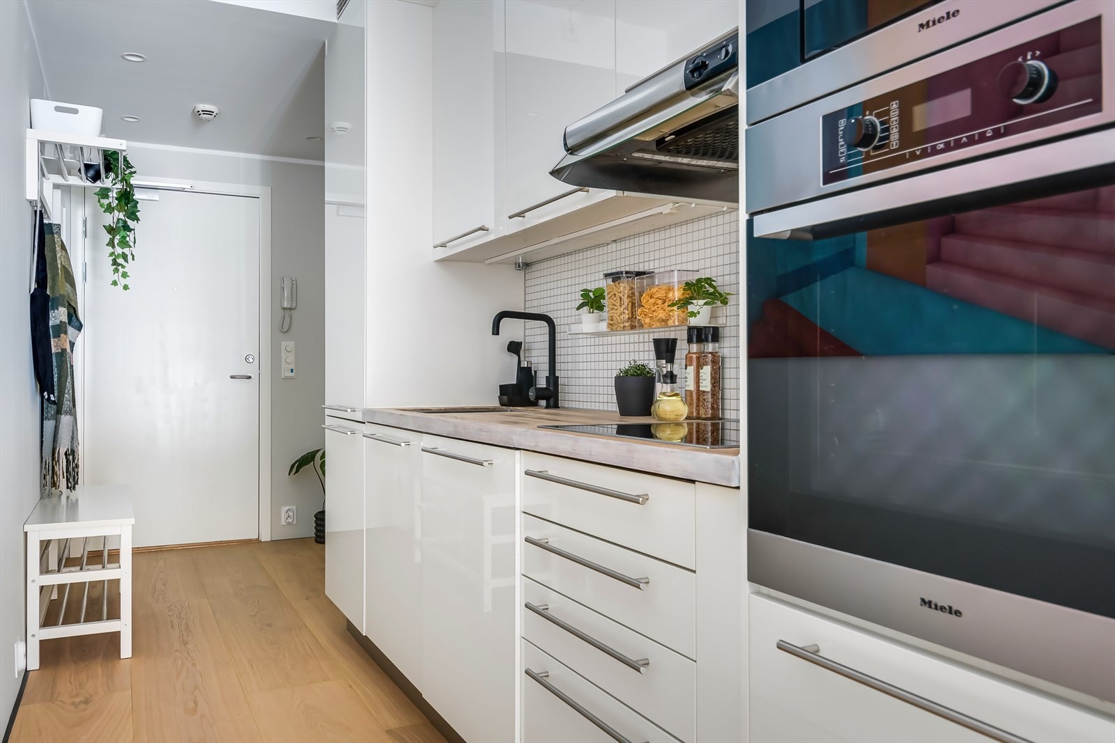 Kjøkkenet er utstyrt med integrerte hvitevarer som kjøl-/fryseskap, oppvaskmaskin, platetopp og stekeovn Galleribilde