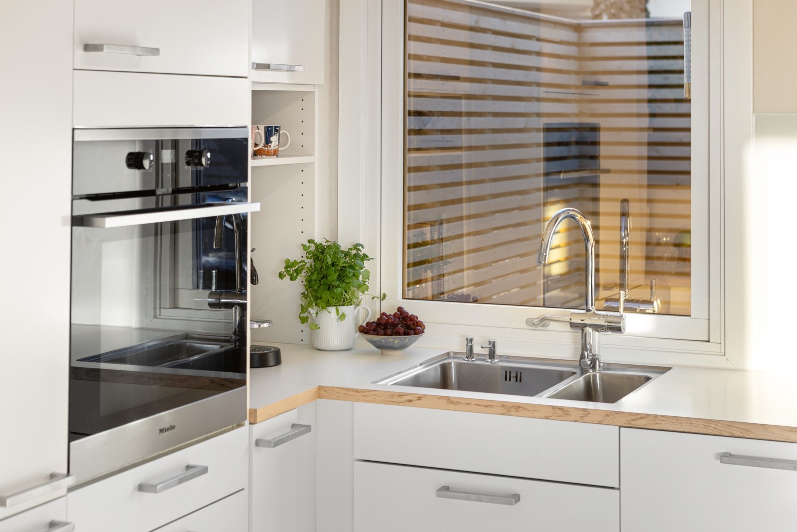 Nedfelt i benken har kjøkkenet dobbel oppvaskkum av rustfritt stål. Alle hvitevarene er integrerte. Ovnen er praktisk plassert i et høyskap. Galleribilde