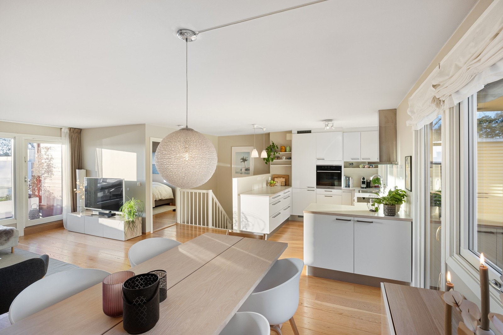 Spisesonen ligger i åpen løsning med kjøkkenet. Dermed blir det hele et lyst og sosialt allrom. På begge ender av allrommet er det utgang til to herlige uteplasser. Galleribilde