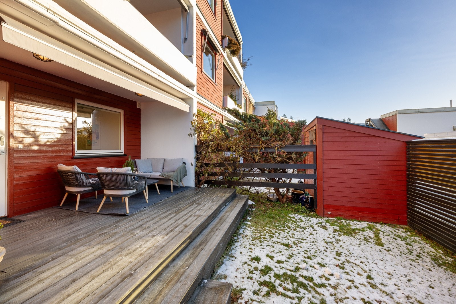 Det er en liten hageflekk ved inngangspartiet, skjermende hekk mot naboen, velstelte beplantninger og høye levegger. Galleribilde