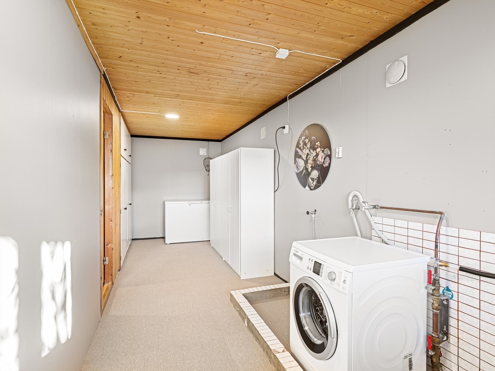 Vaskerom med god lagringsplass i hyllesystem og i garderobeskap. Rommet er nylig malt. Galleribilde