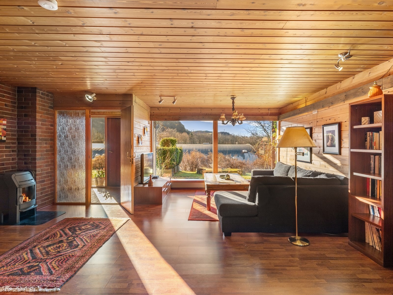 Entre/vindfang med dør inn til hall/kjellerstue.
Kjellerstue med store vinduer som slipper mye naturlig lys inn i rommet. Innredet som ekstra stue. Galleribilde