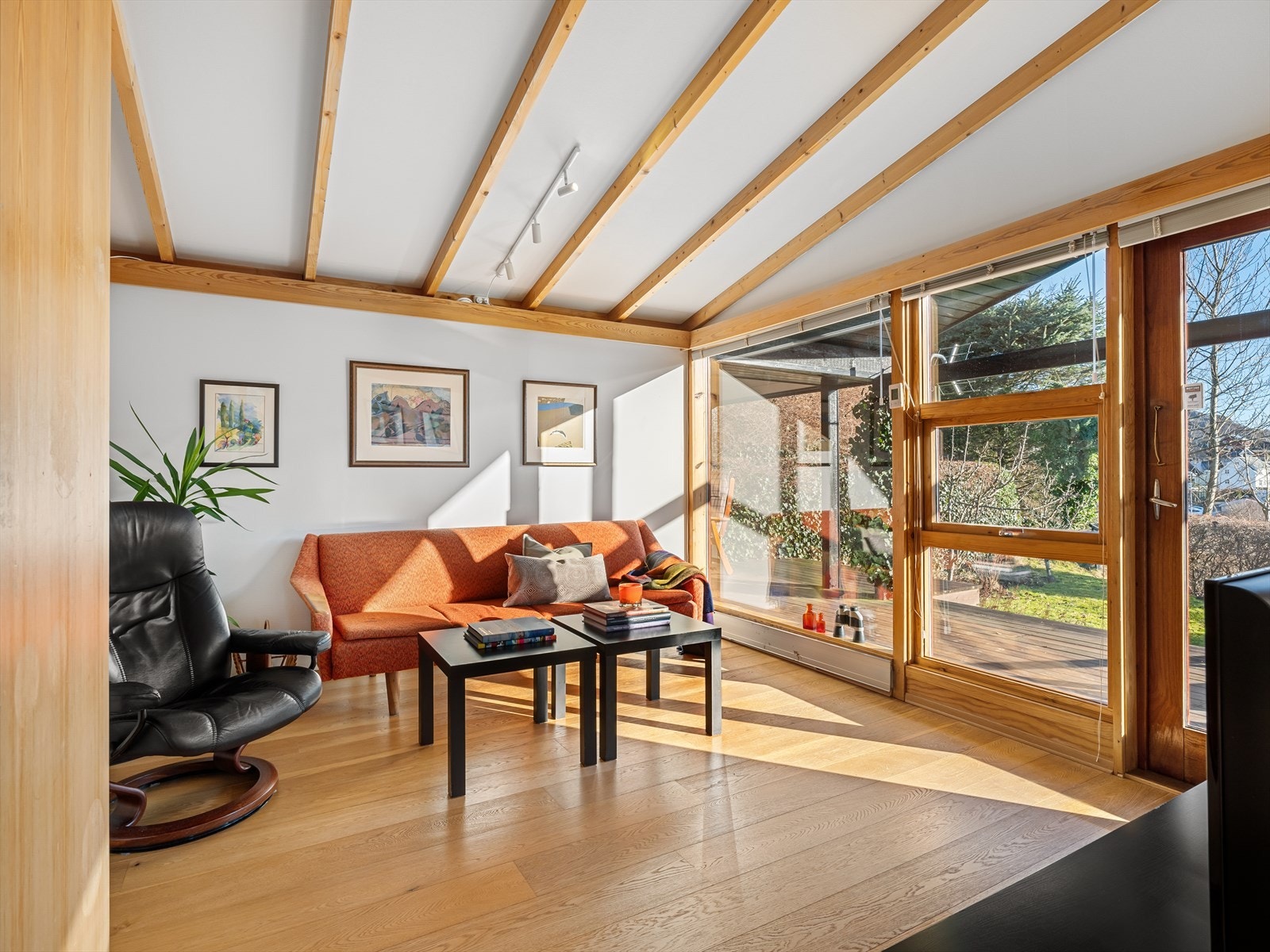 TV-stue med ekstra god takhøyde og utgang til terrasse med takoverbygg Galleribilde
