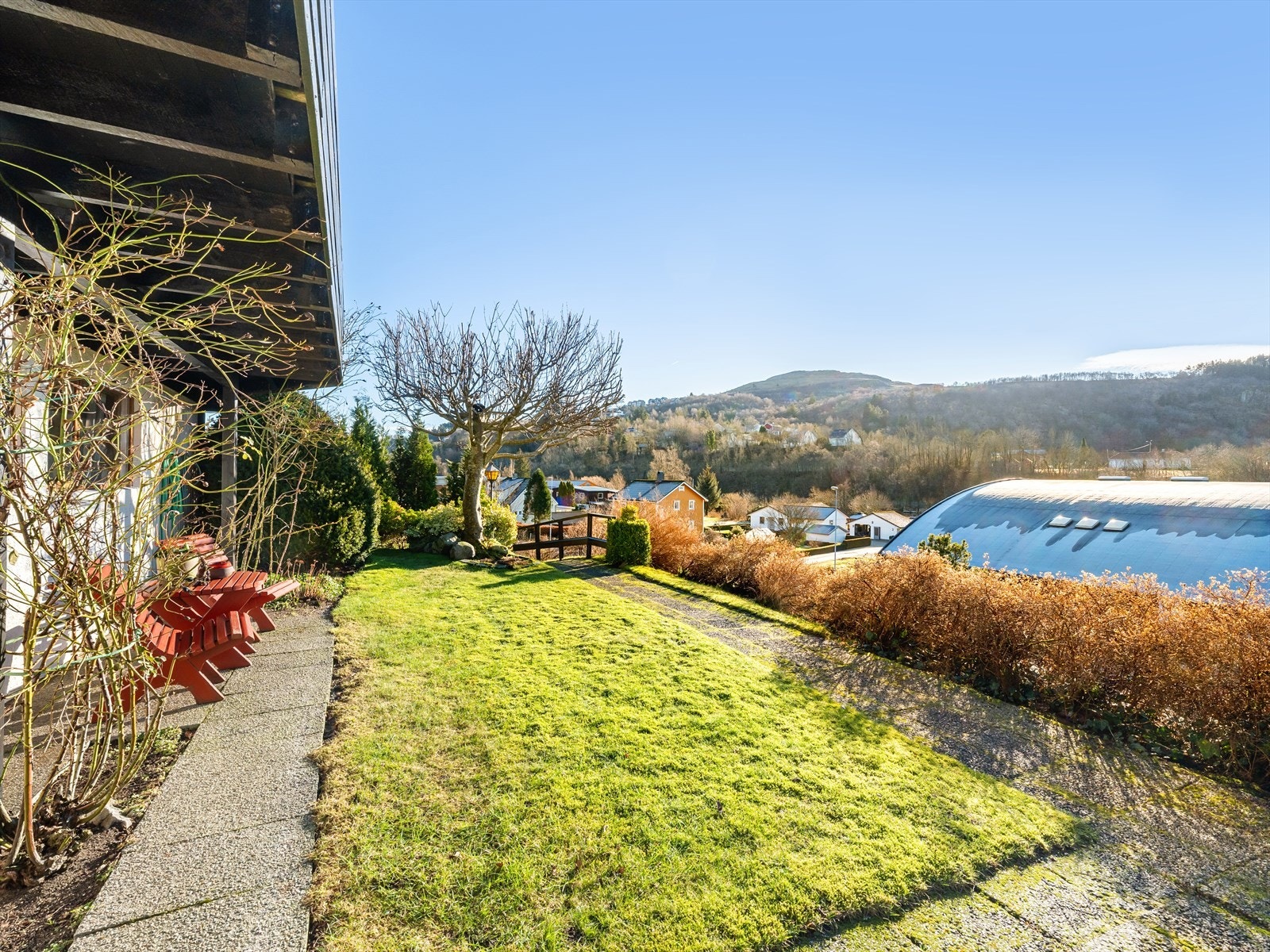 Tomten er opparbeidet med terrasser, plener og beplantning Galleribilde