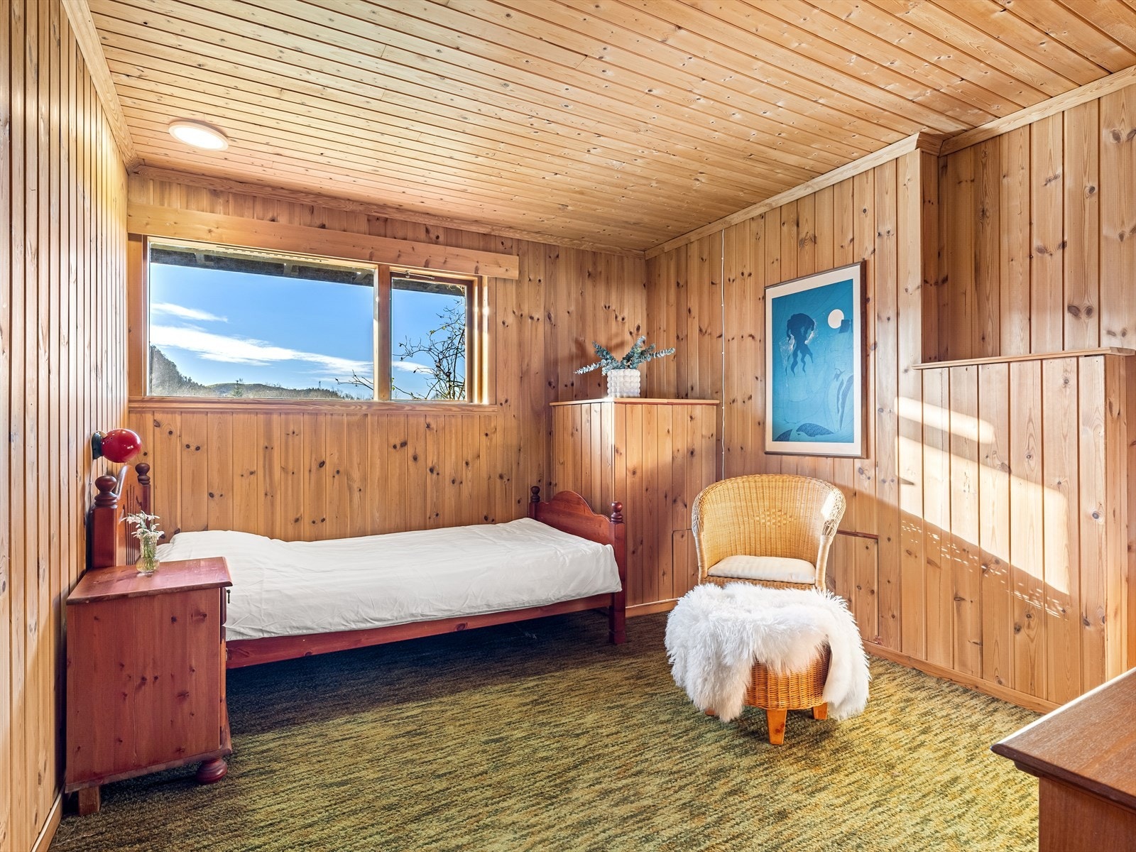 Romslig soverom med teppe på gulv og panel i vegger og tak. Galleribilde