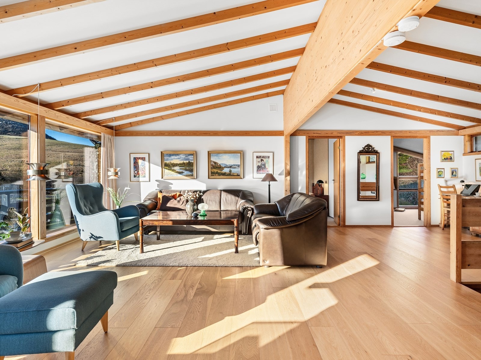 Enstavs eikeparkett på gulv. Lyse vegger og tak med trebjelker skaper særpreg. Galleribilde