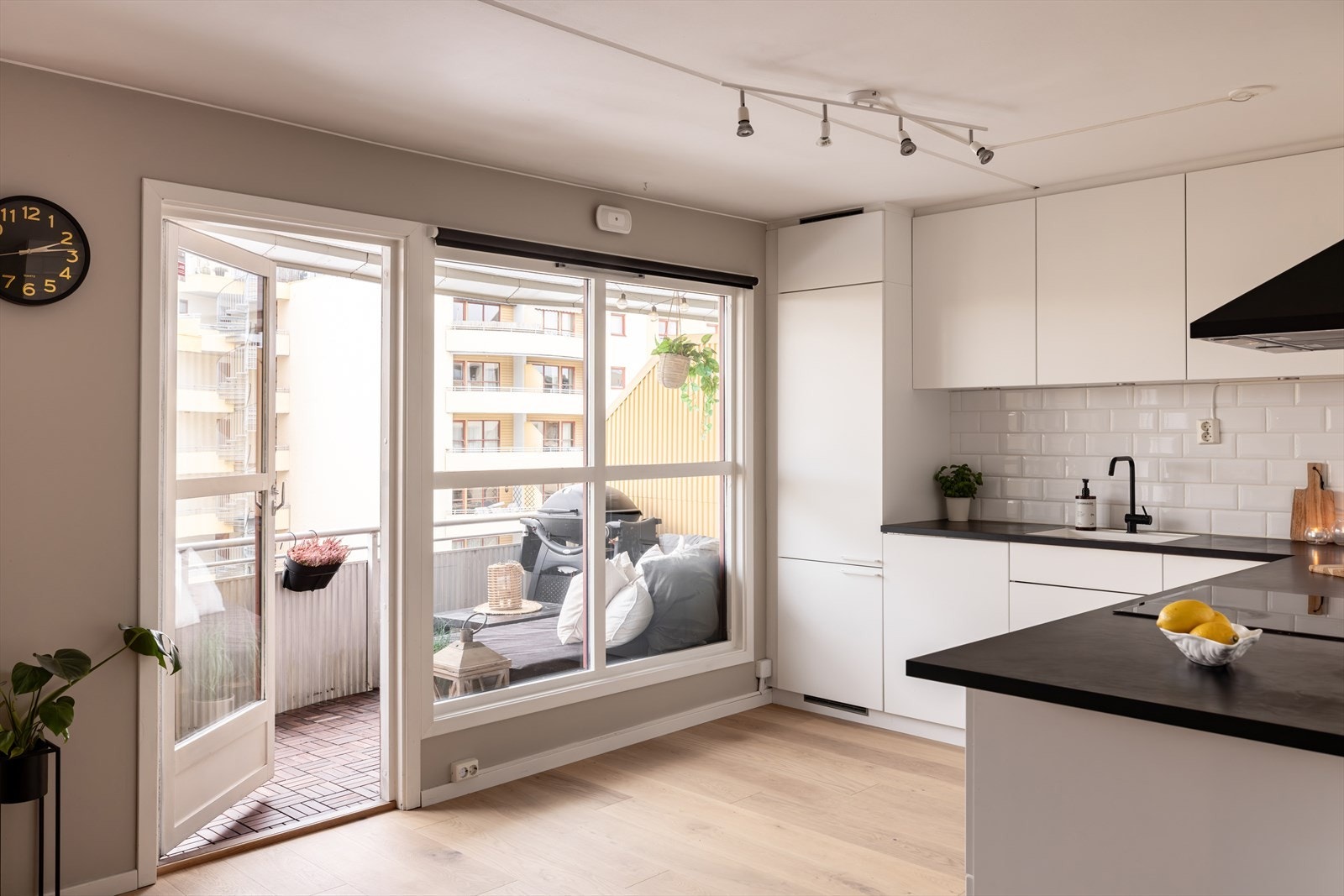 Lekkert kjøkken fra 2016 innredet med hvite, slette fronter og fine fliser på veggene Galleribilde