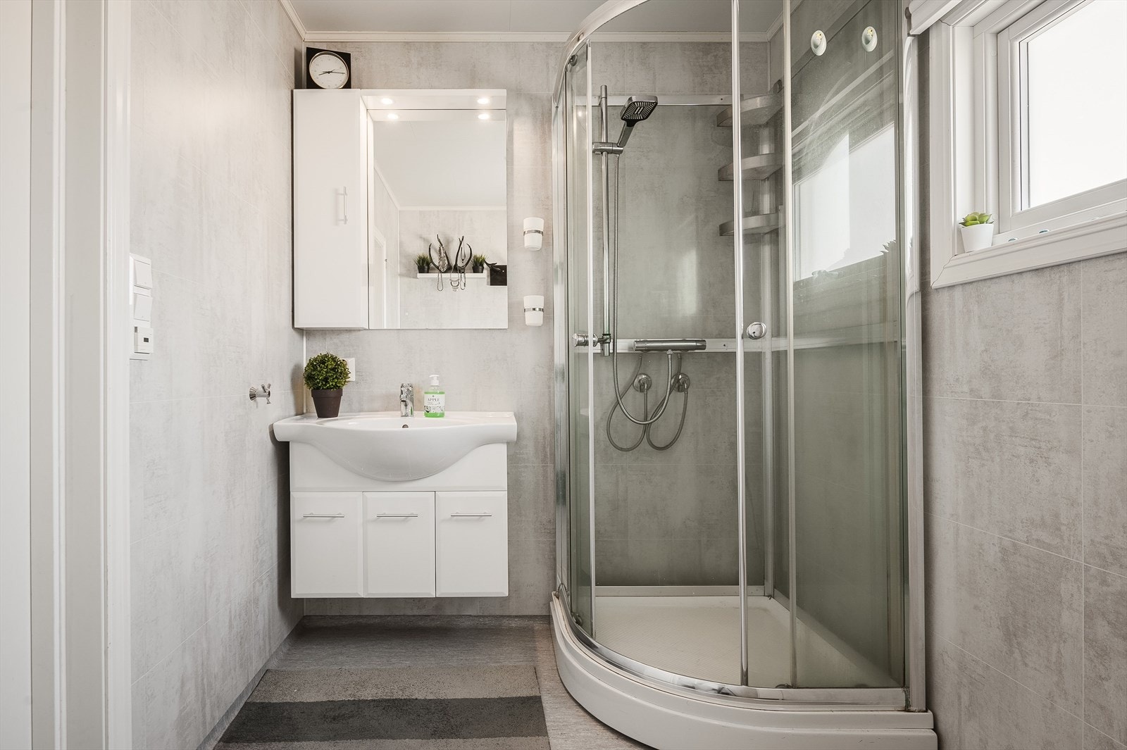 Det andre baderommet har belegg på gulv med gulvvarme, våtromsplater på veggene og elektrisk styrt vifte. Baderommet er utstyrt med servantskap, speil med belysning, dusjkabinett og toalett. Galleribilde