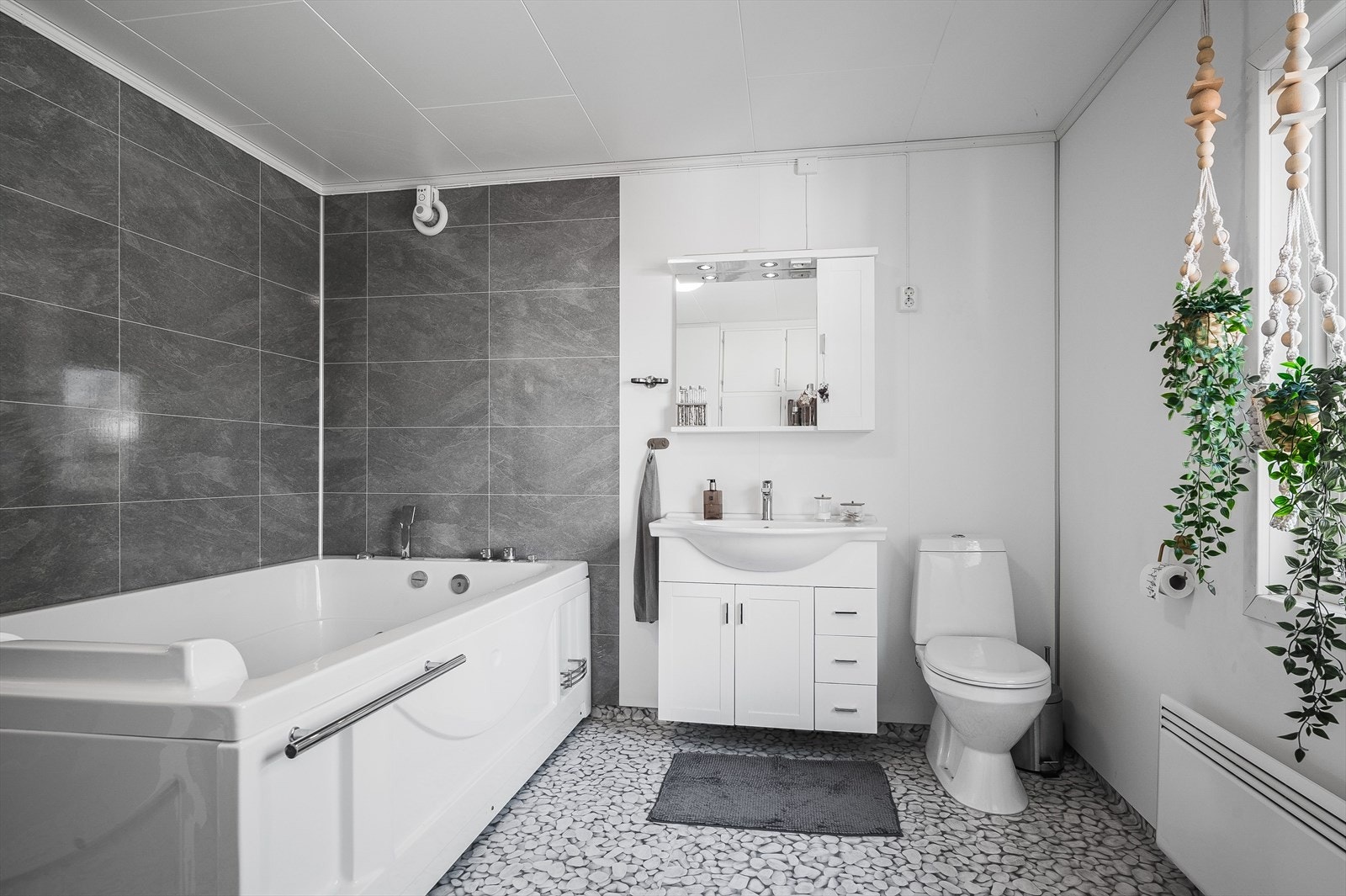 Baderommet er utstyrt med servantskap, speil med belysning, boblebad, gulvstående toalett og panelovn. Det er også flere plassbygde garderobeskap med god oppbevaringsplass. Galleribilde