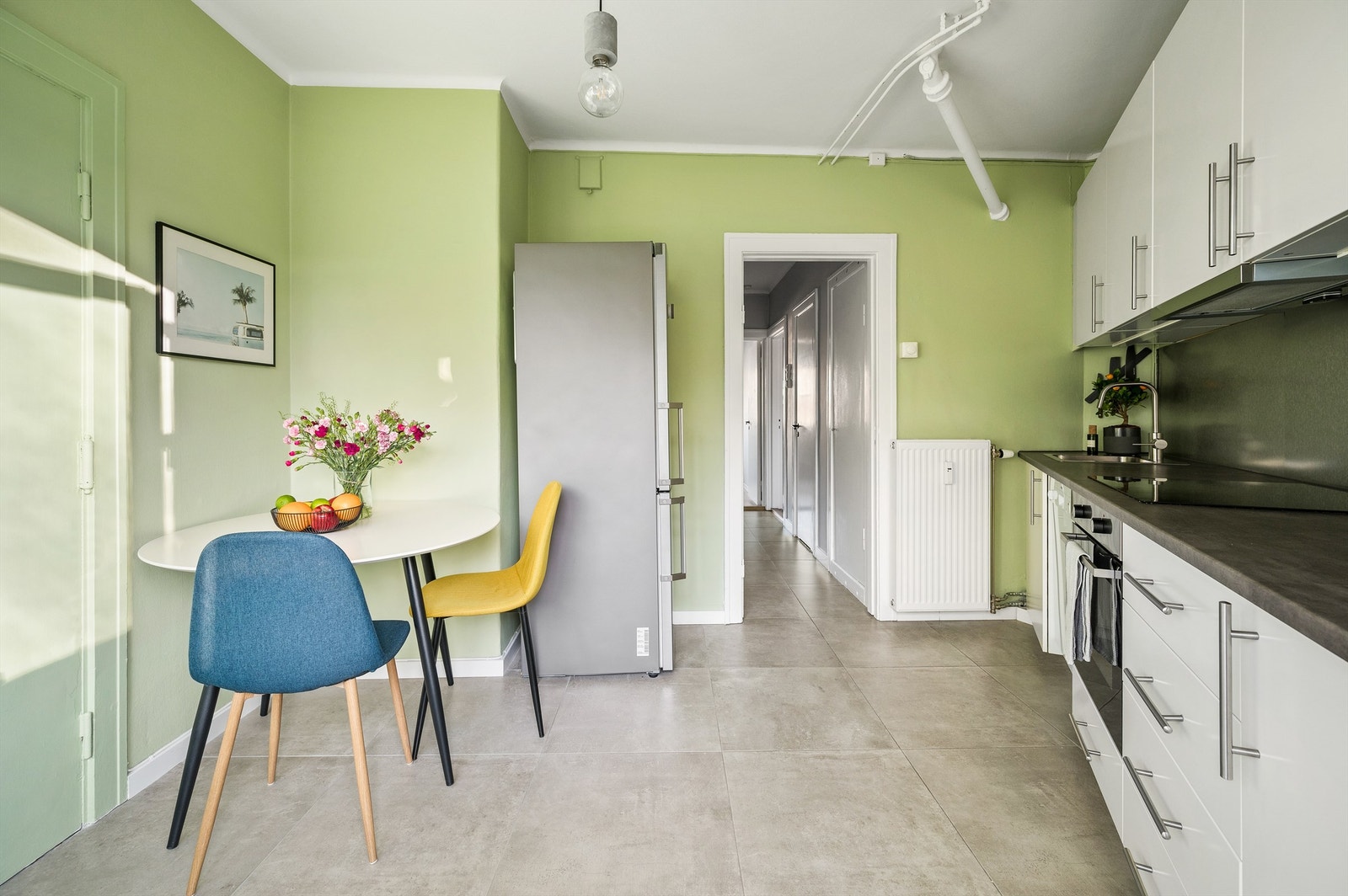 Balkongdøren gir kjøkkenet rikelig med naturlig lysinnslipp, og skaper en lys og fin atmosfære. Galleribilde