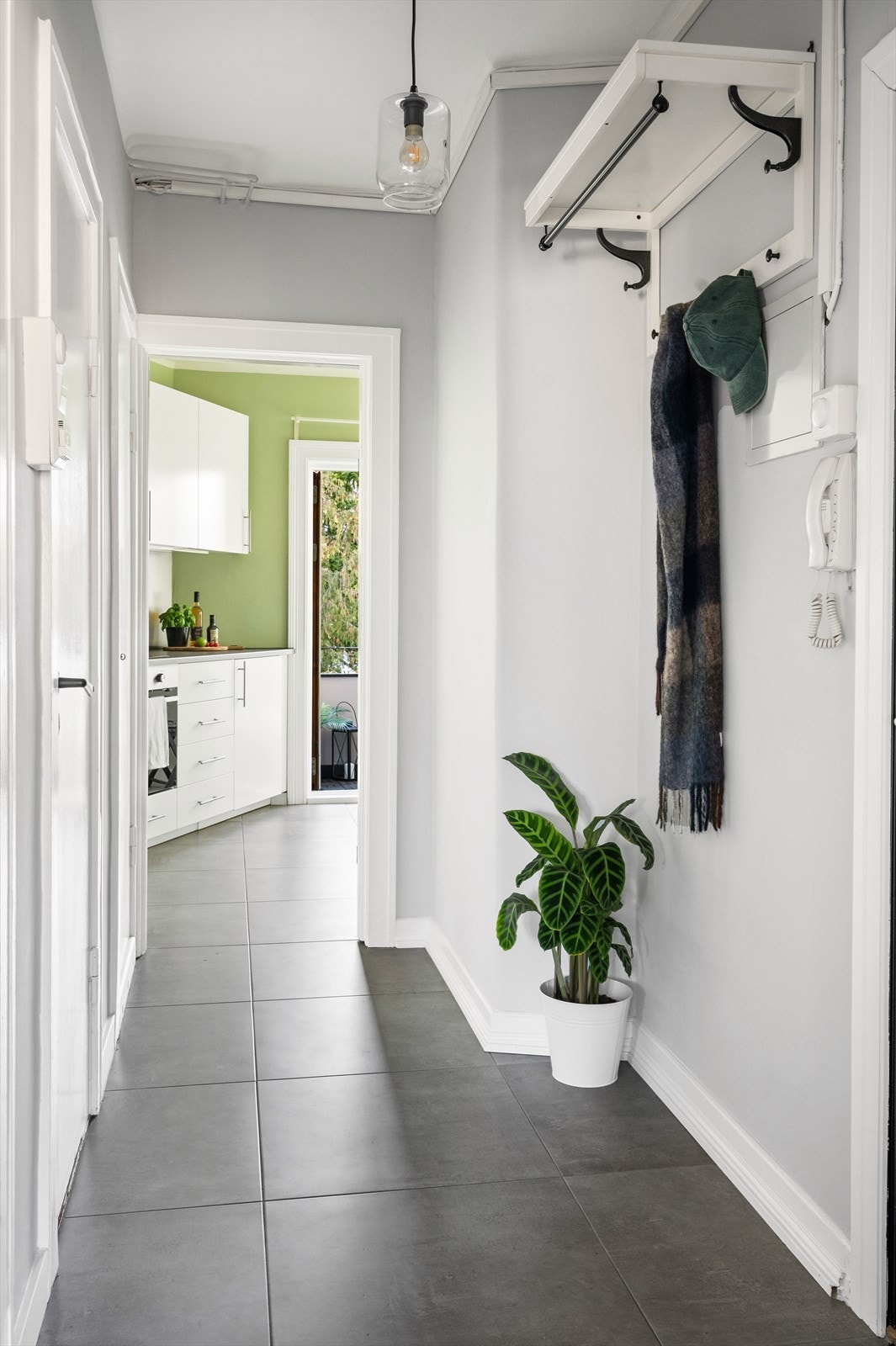 Innbydende entré med callinganlegg, flislagt gulv og felles tilknytning til alle rom i leiligheten. Her er det god plass til å henge fra seg yttertøy. Velkommen inn! Galleribilde