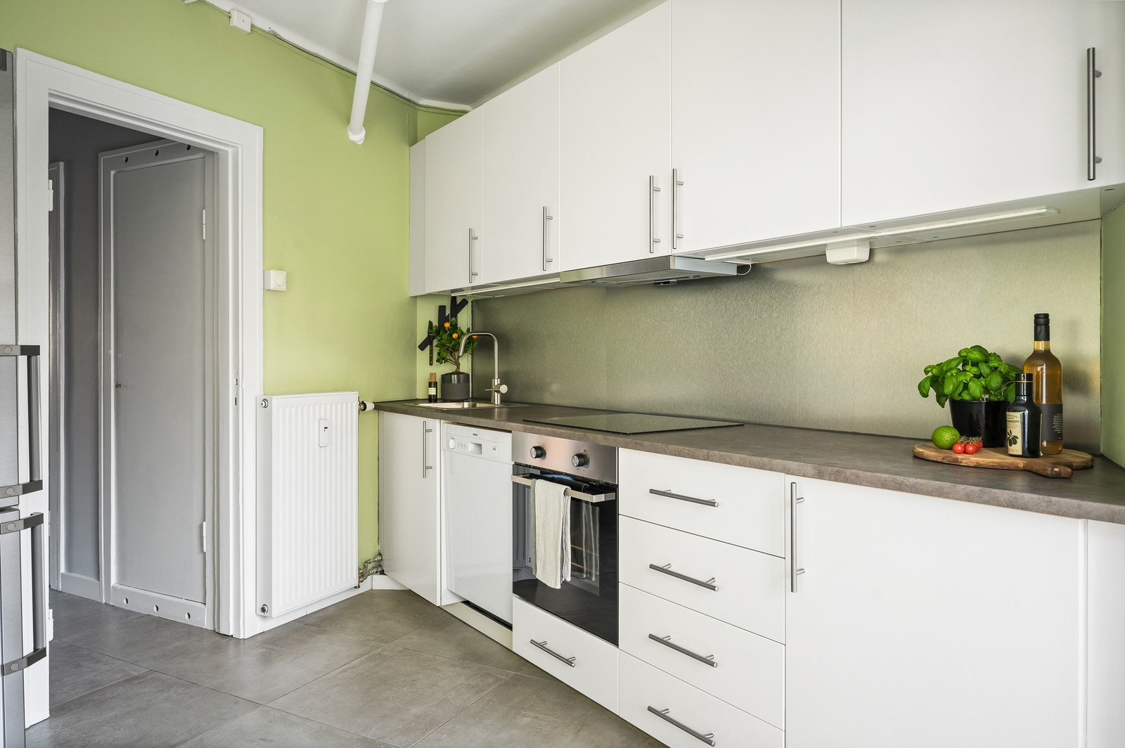 Benkeplaten er av laminat og det er nedfelt oppvaskkum med ett-greps armatur. Under overskapet er det belysning og stikkontakt. Integrert stekeovn, platetopp og oppvaskmaskin. Galleribilde