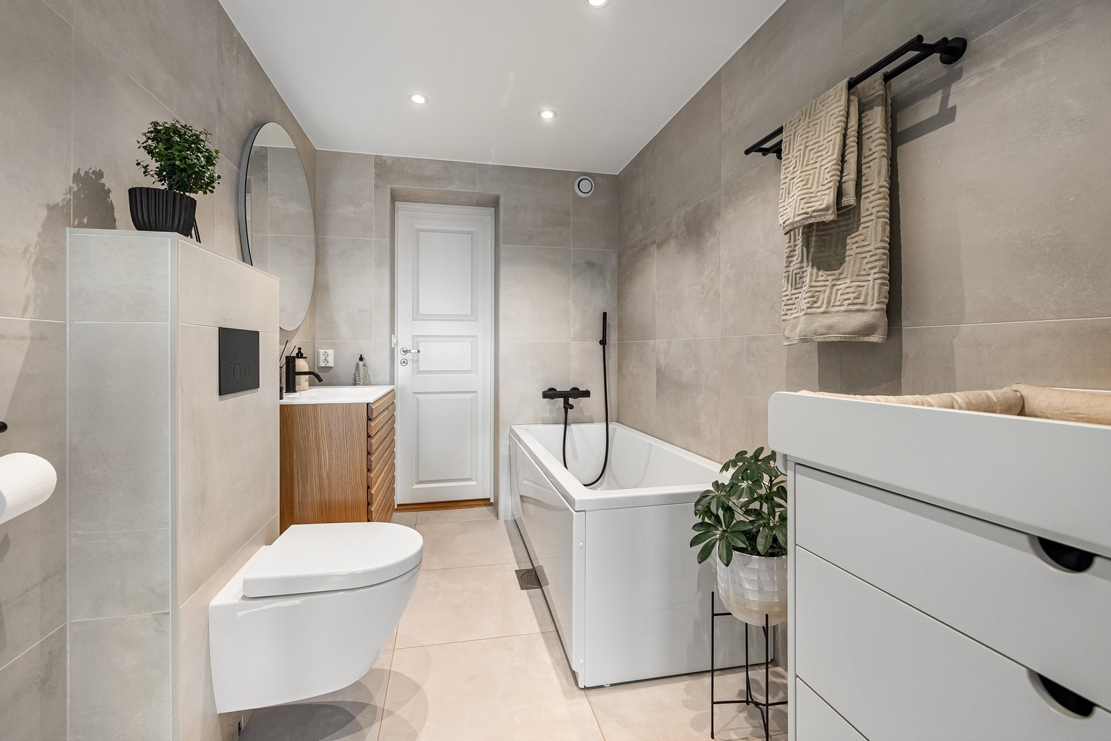 Sandfargede fliser med sorte detaljer gir dette badet spa-følelsen du bare kan drømme om! Badekar er noe både store og små vil verdsette i hverdagen. Galleribilde