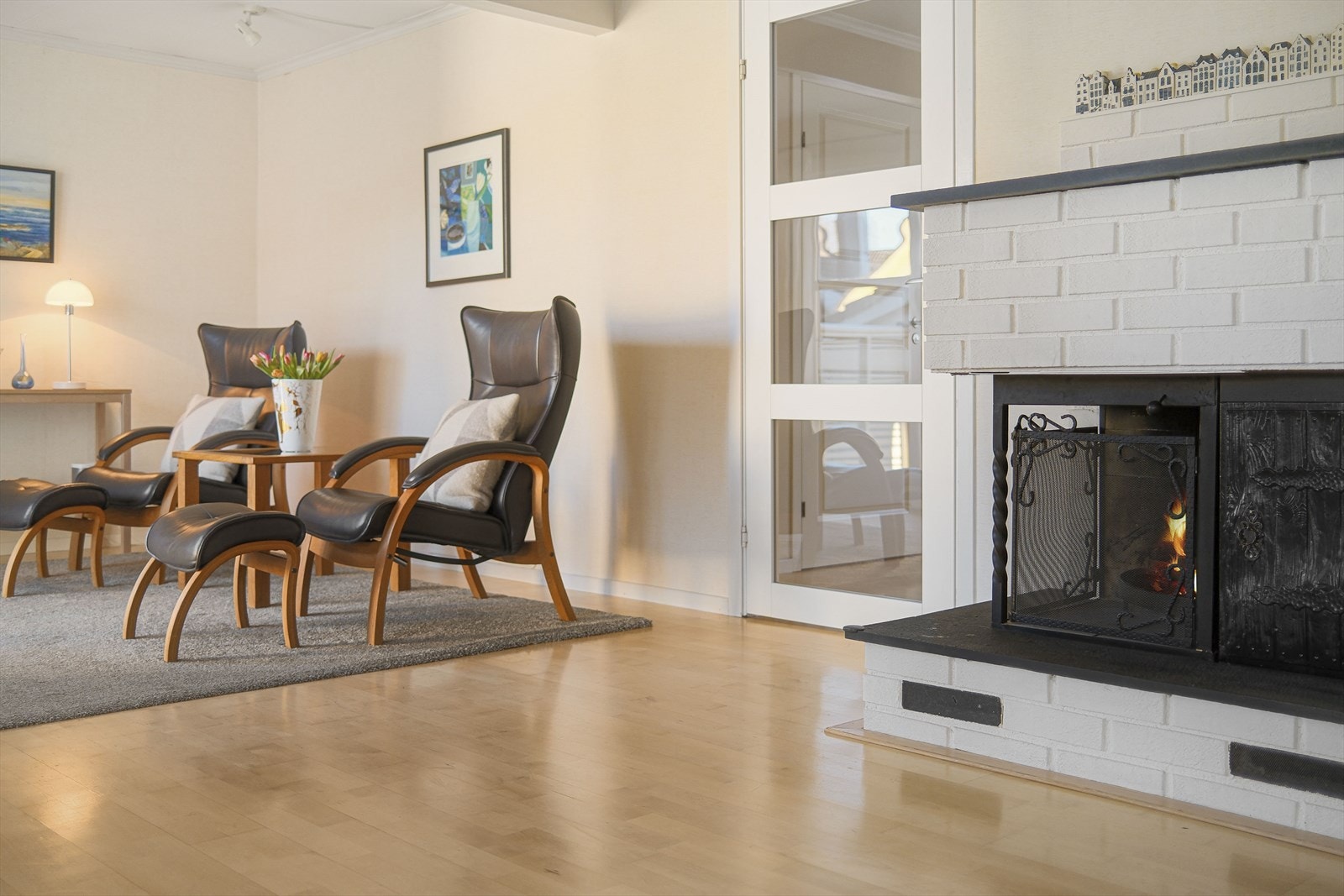 I stuen er det både åpen peis og lukket, effektiv vedovn. Glassdør mellom stue og spisestue Galleribilde