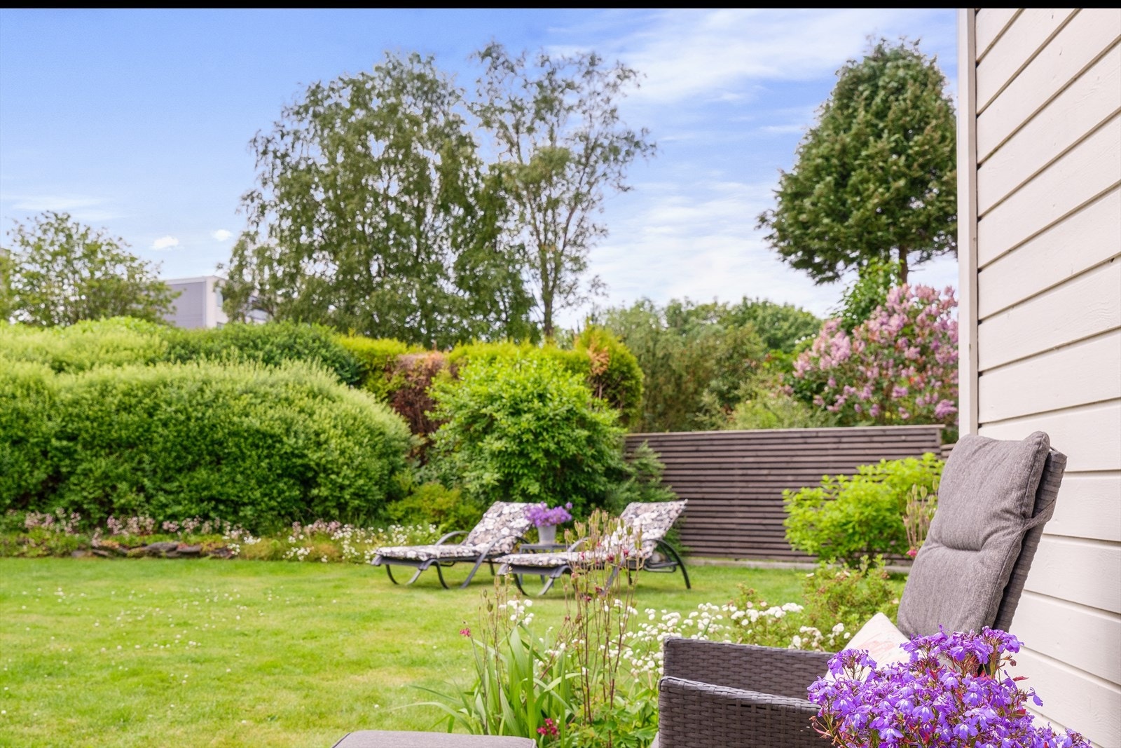 Lys og innbydende hage med frodige busker. Perfekt for avslapning og sosiale sammenkomster. Galleribilde