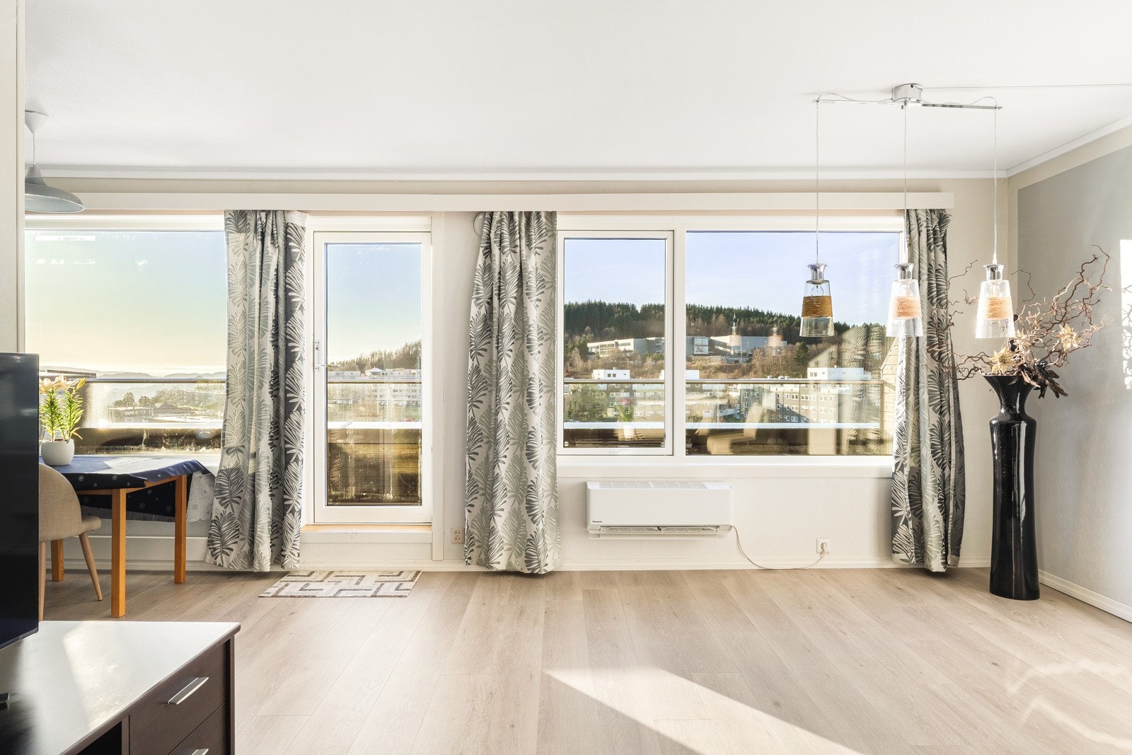 Store vinduer og balkongdøren gir rikelig med dagslys inn til stueområdet. Galleribilde