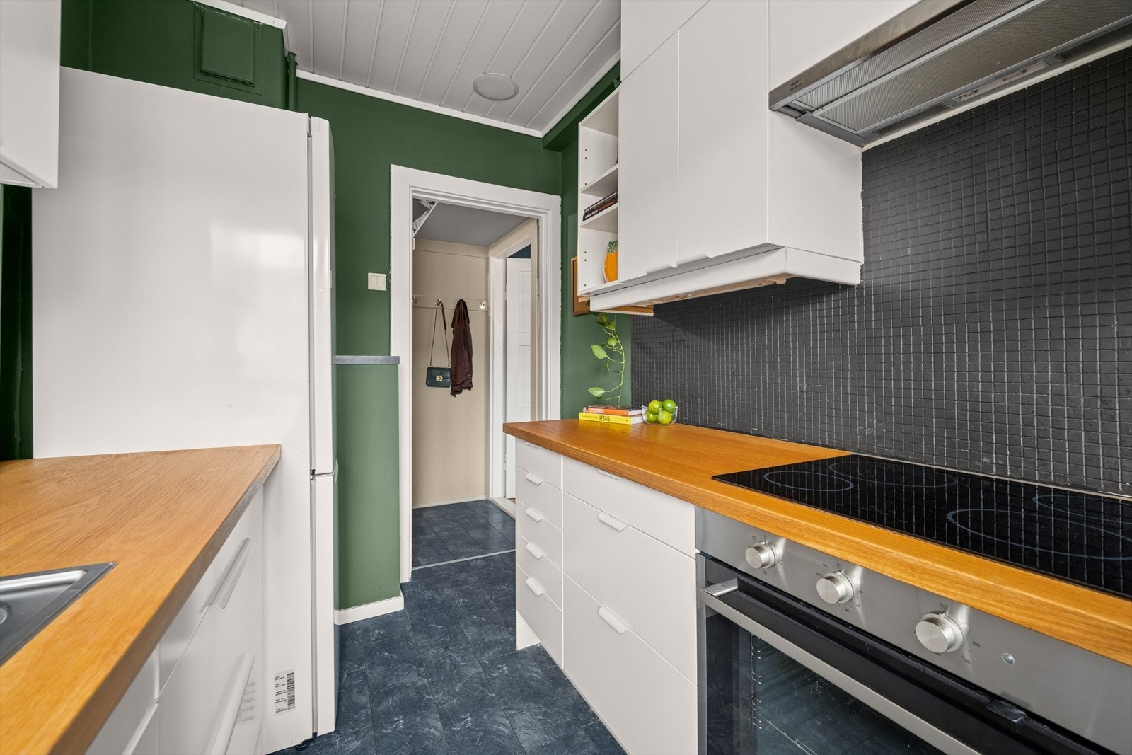 Kjøkkenet er utstyrt med integrerte hvitevarer samt frittstående kjøleskap Galleribilde