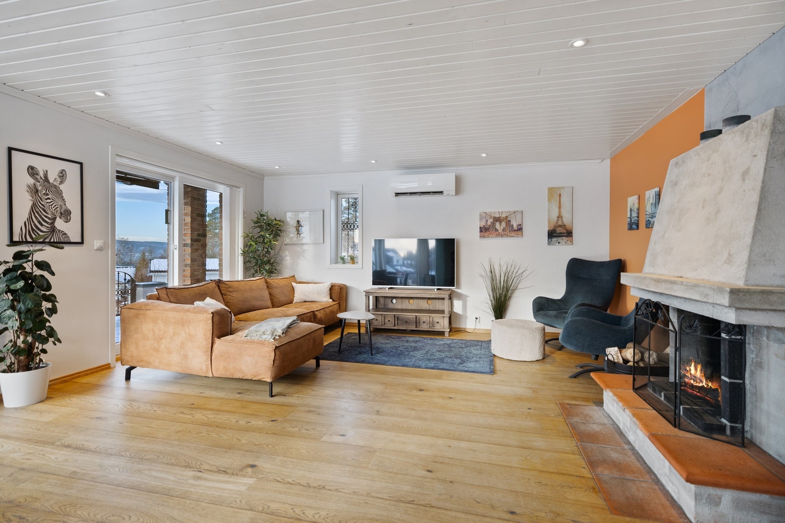 Stuen kan deles inn i flere soner og den store, flotte peisen gir godt med varme på kjølige dager. Galleribilde