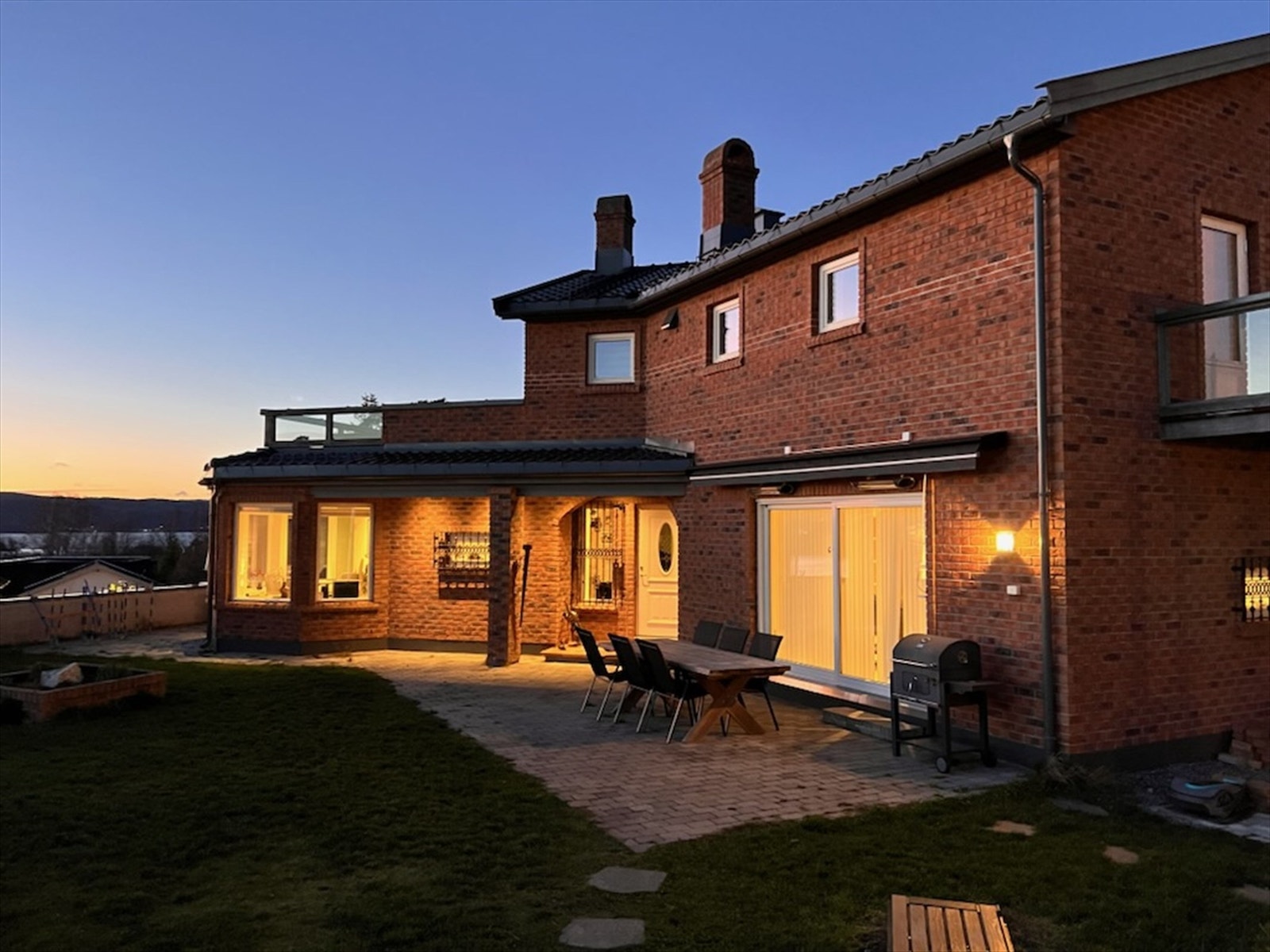 Nyt en hyggelig kveldsstemning med en fantastisk utsikt mot fjorden, hvor solnedgangen maler himmelen i vakre farger. Galleribilde