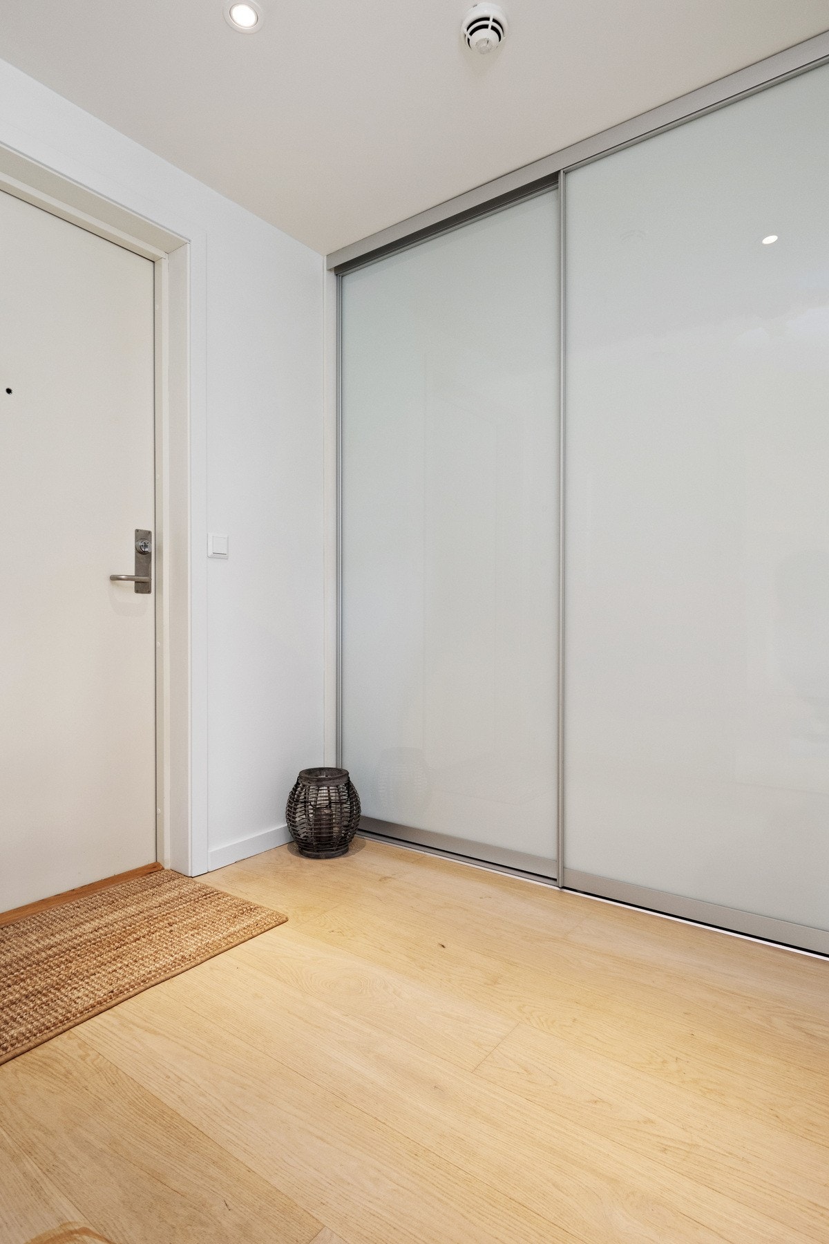Det er god plass til yttertøy, sko, klær og utstyr i en stor, plassbygd skyvedørsgarderobe med hvite fronter. Galleribilde