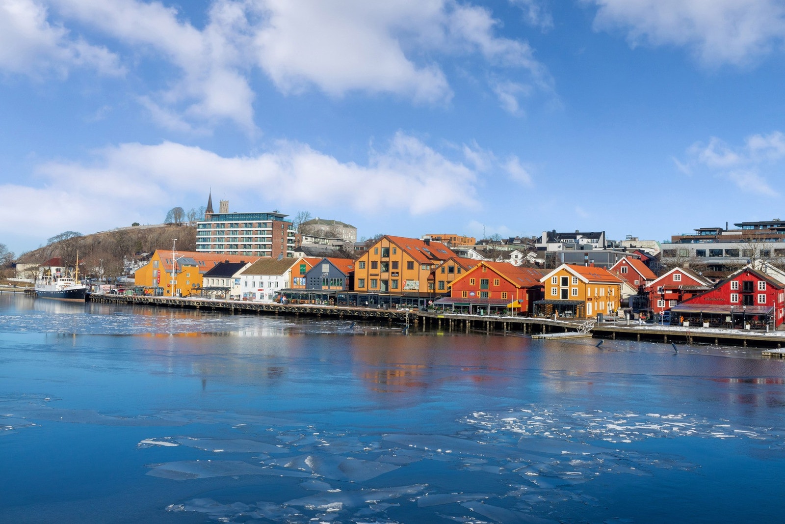 Her kan du vandre langs bryggekanten, nyte utsikten mot fjorden og Slottsfjellet, eller stikke innom en urban kafé. Galleribilde