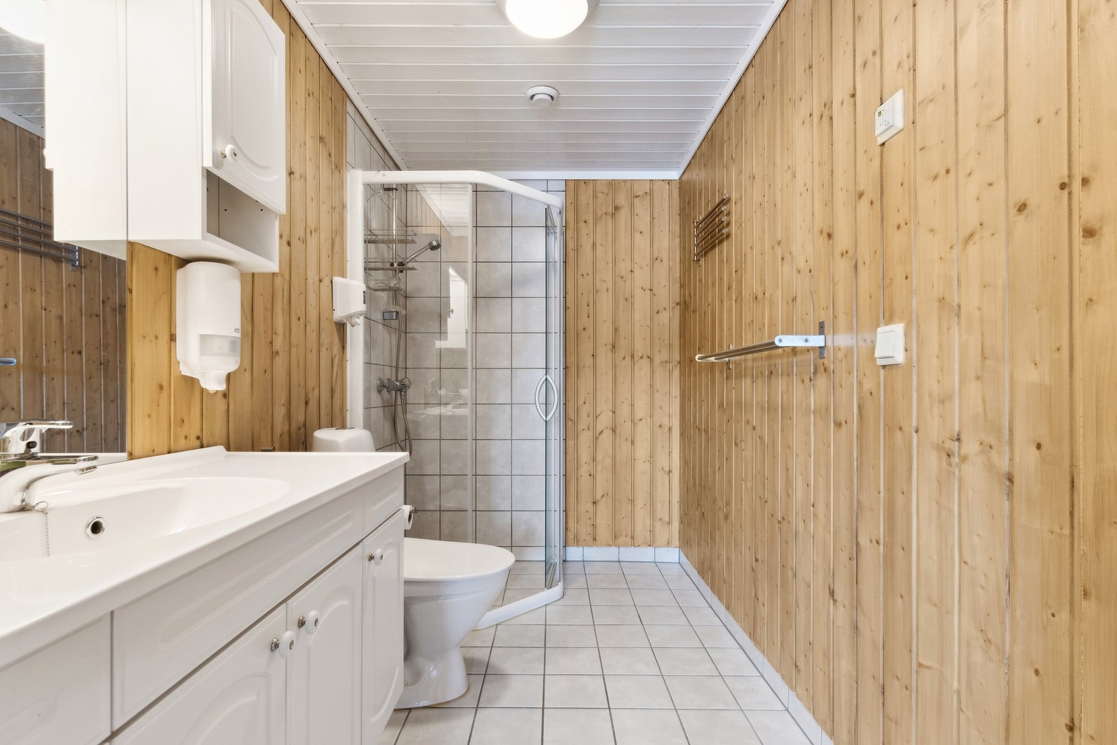 Bad på 4,5 kvm med flislagt gulv og dusjhjørne. Galleribilde