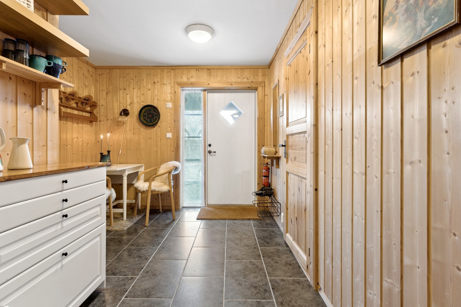 Rommet har flislagt gulv med gulvvarme og panel på vegger. Galleribilde