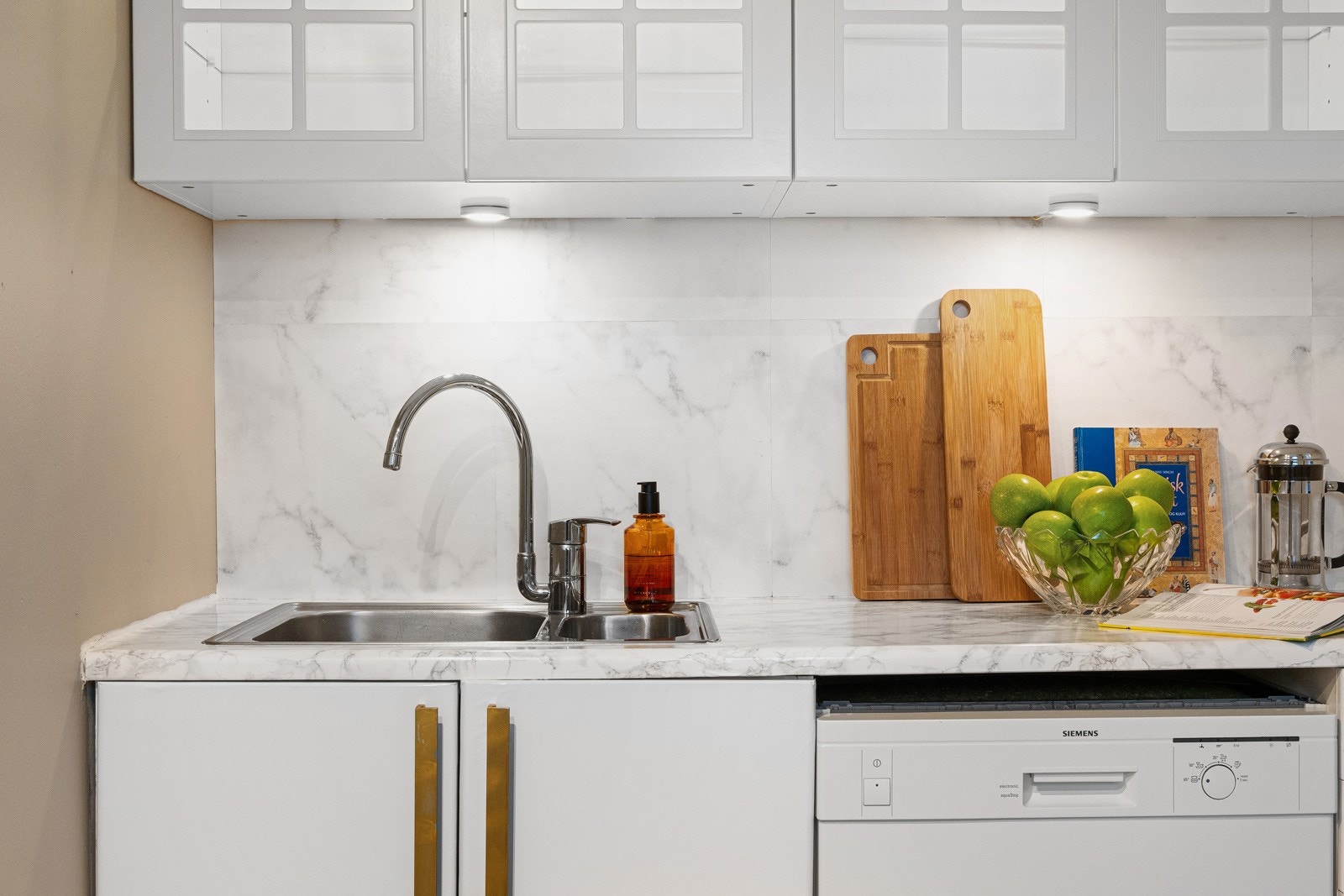 Innredningen er hvit med slette fronter og laminat benkeplate. Galleribilde