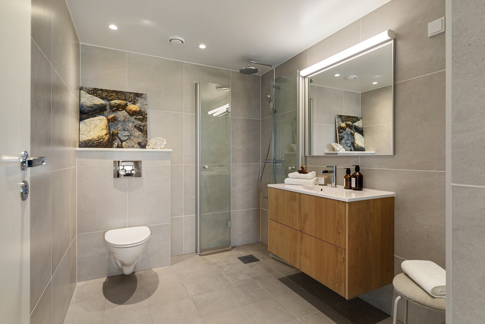 Innbydende og flislagt baderom med opplegg for vaskemaskin Galleribilde